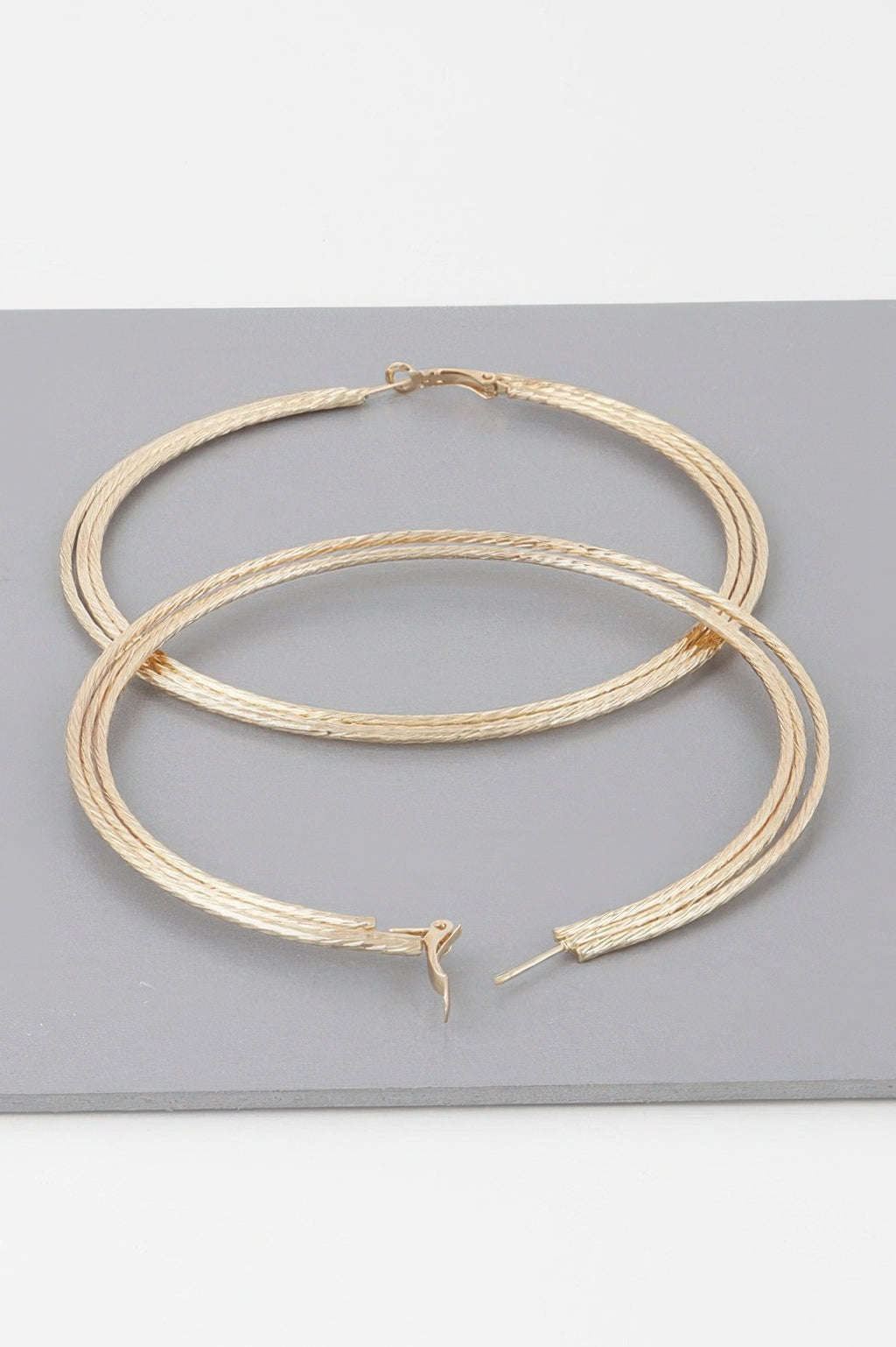 Gold wide triple rope hoop earrings: two hoops with rope texture and hook details
