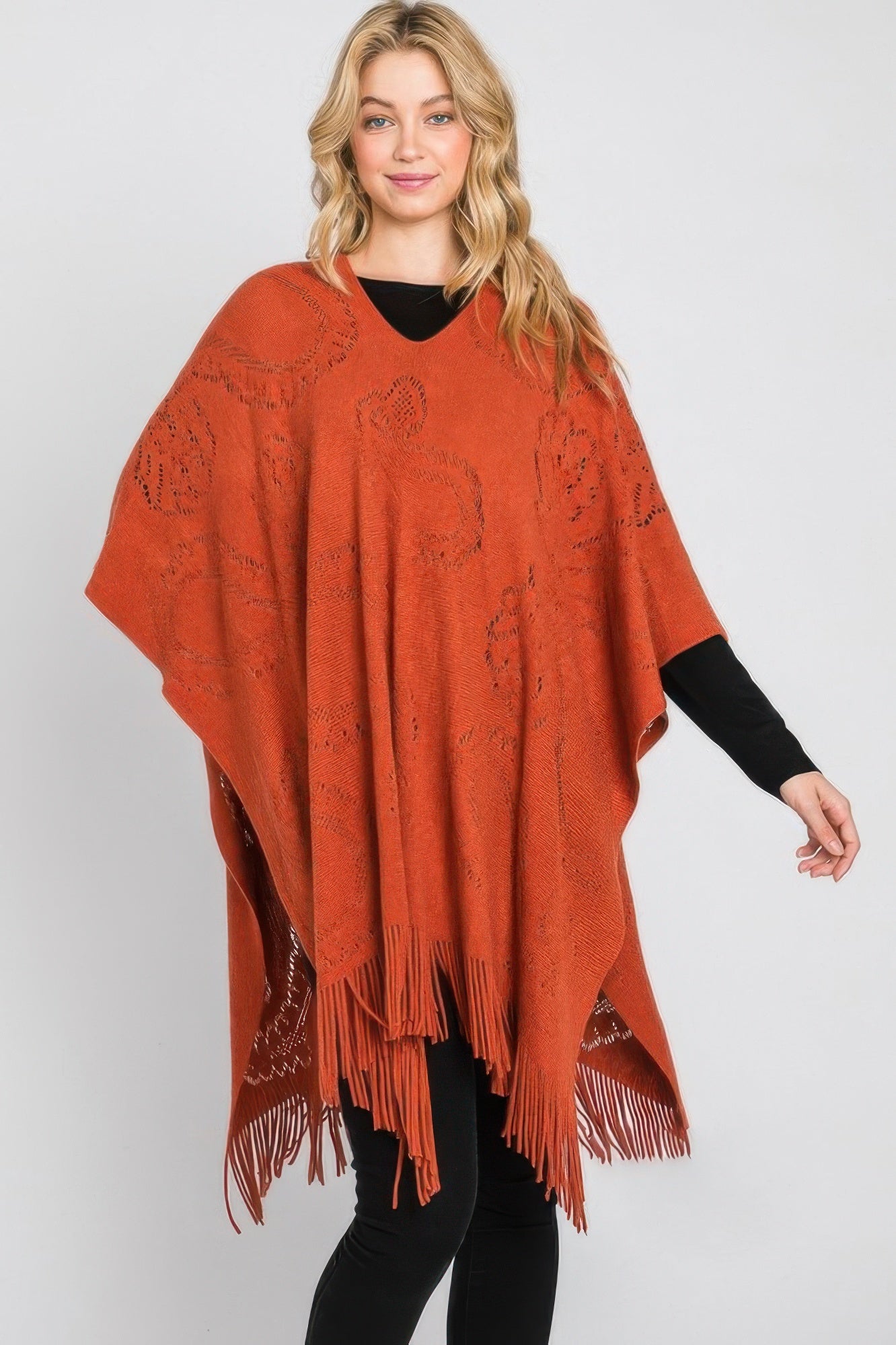 Rust orange paisley poncho with V-cut neckline and long fringe along the bottom edge.
