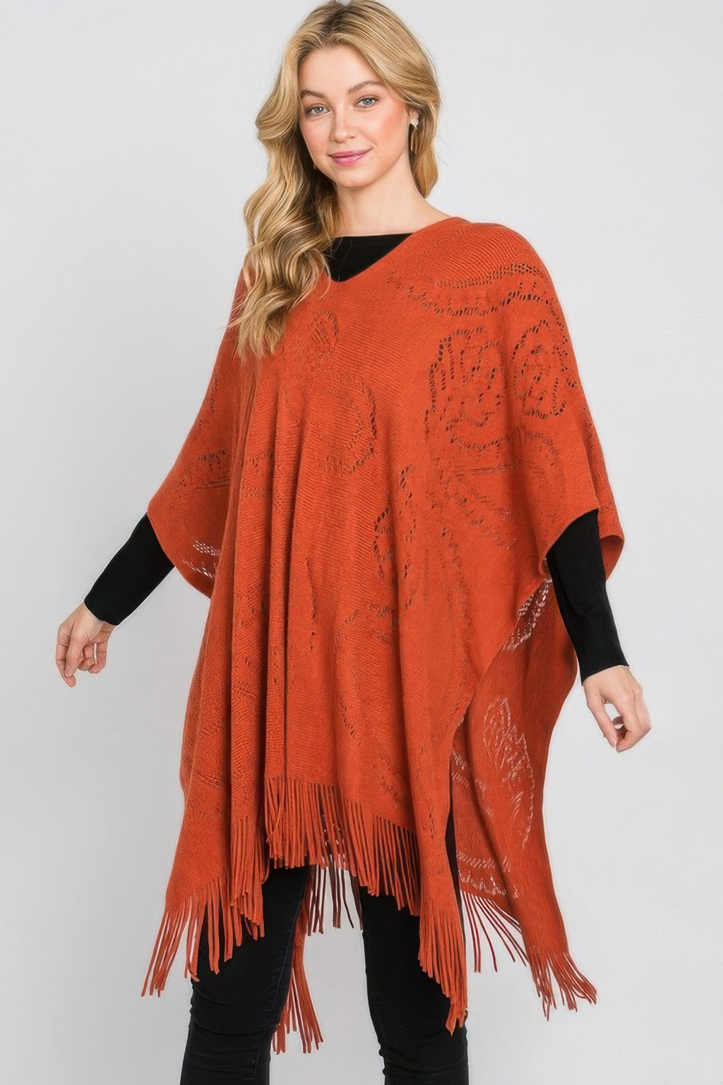 Rust paisley poncho with detailed front knit pattern and fringe along the lower edge.