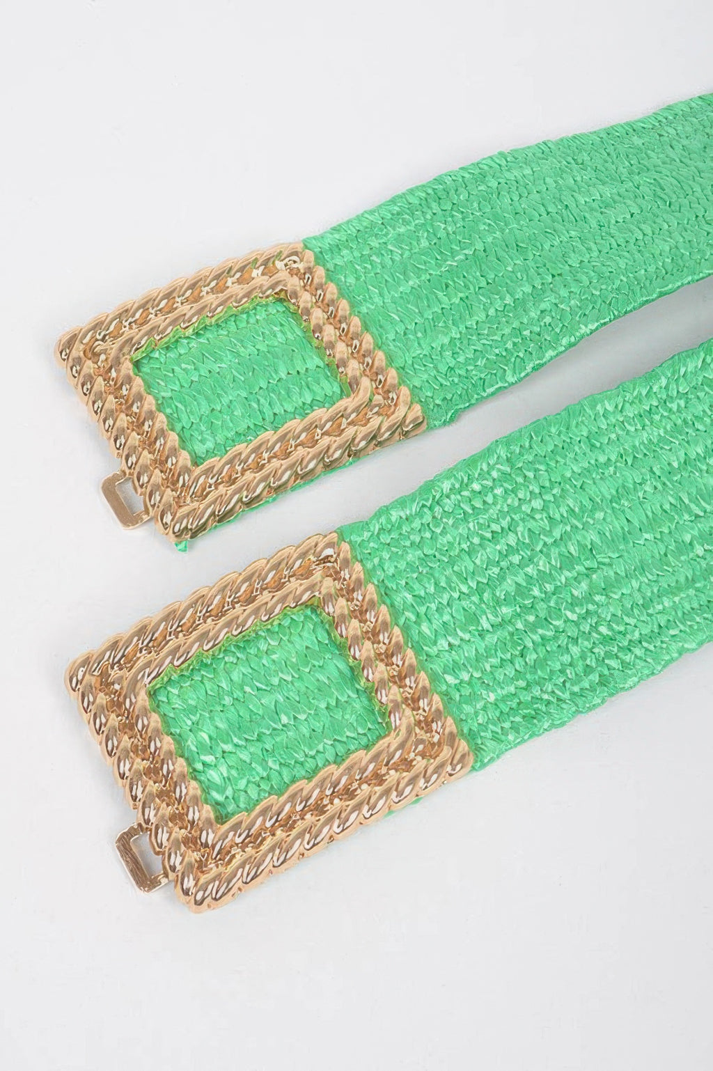 Close-up of green belt buckles: square gold-look frames with faux straw weave