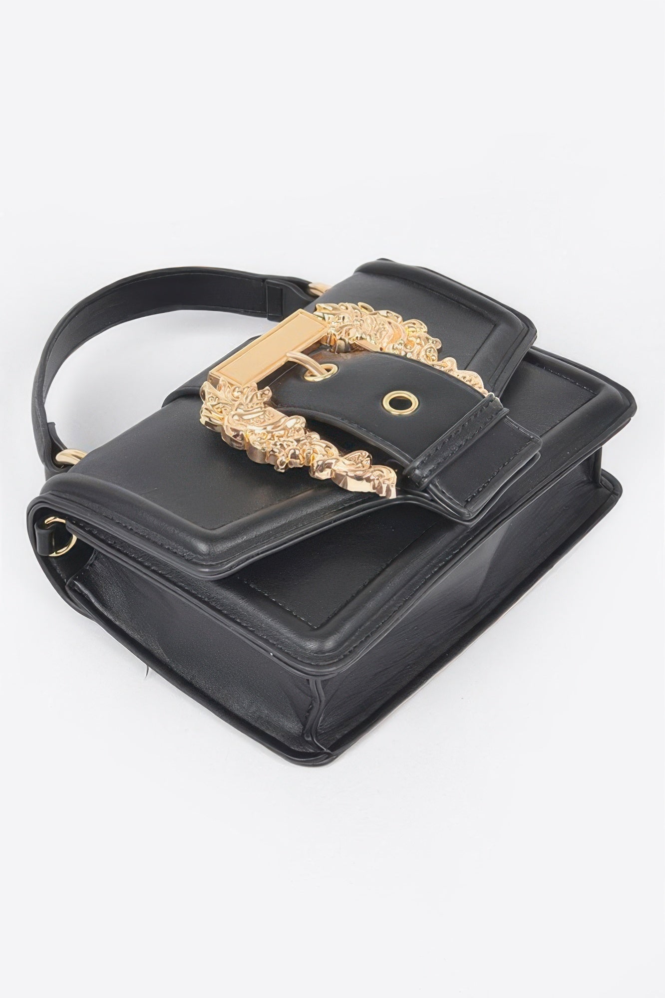 Black vegan clutch with top handle, gold chain strap, and ornate front buckle