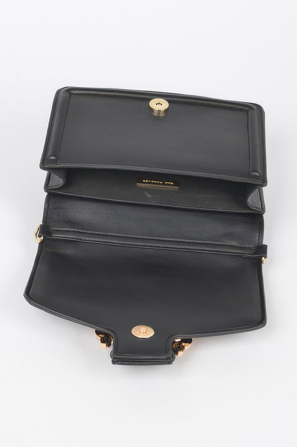 Open black vegan clutch bag with gold turn-lock snap on the flap