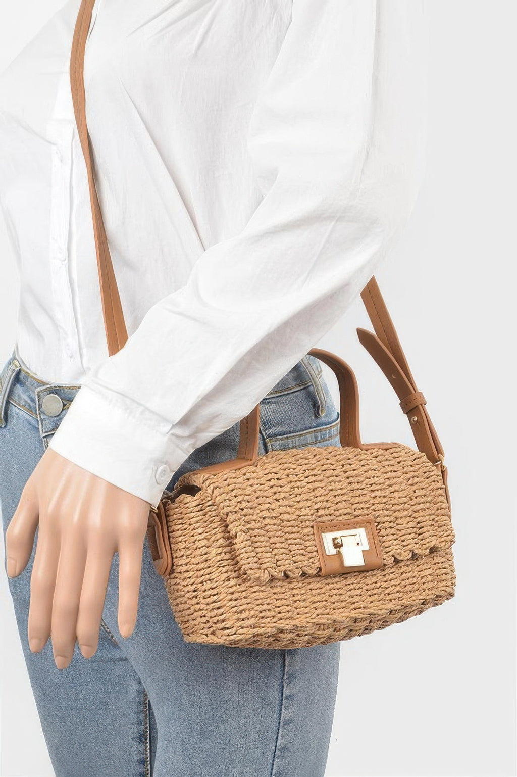 Faux straw top handle bag in khaki worn crossbody with tan strap and front clasp