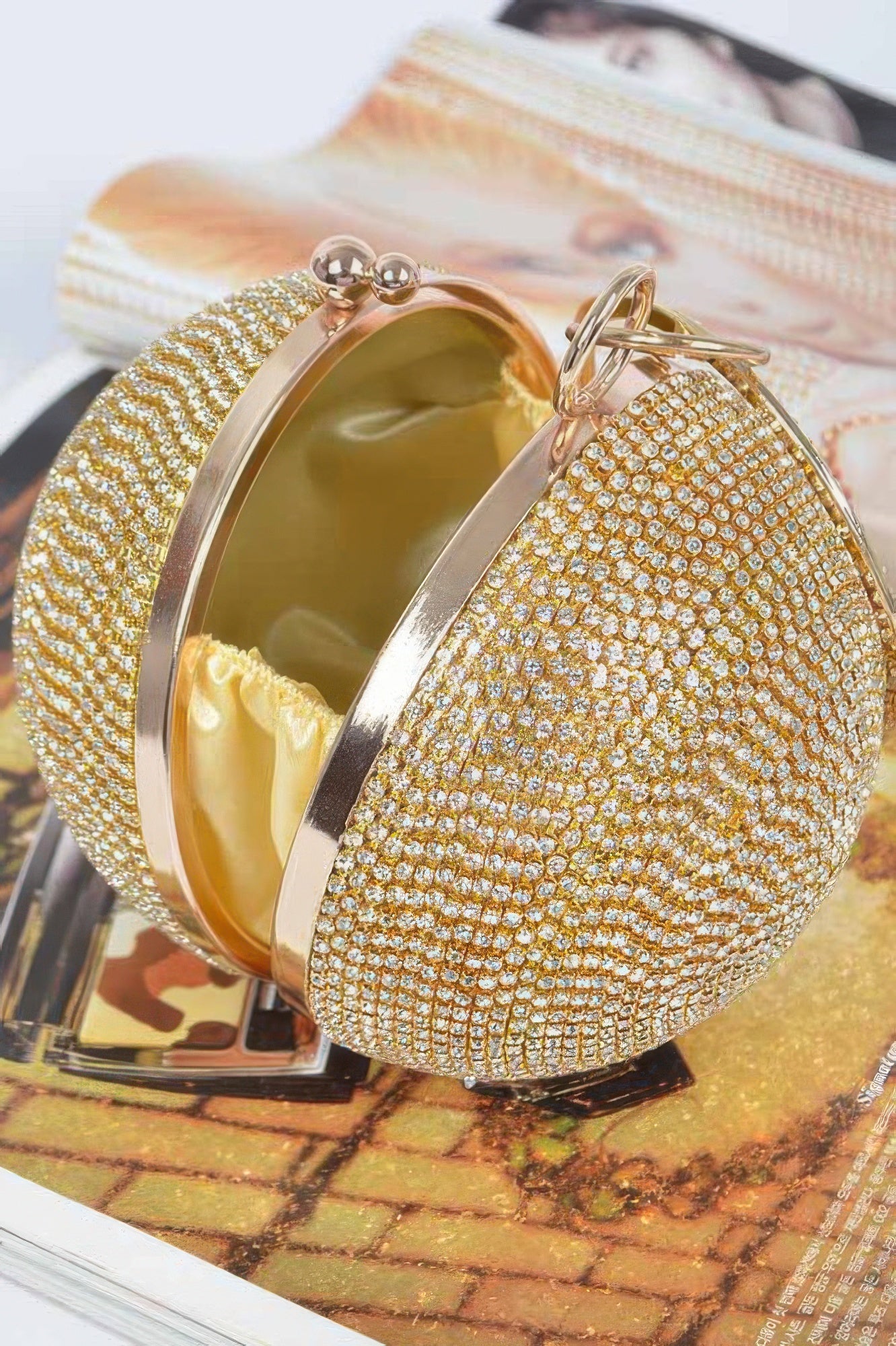 Gold rhinestone ball clutch with interior shine and hinged clasp frame