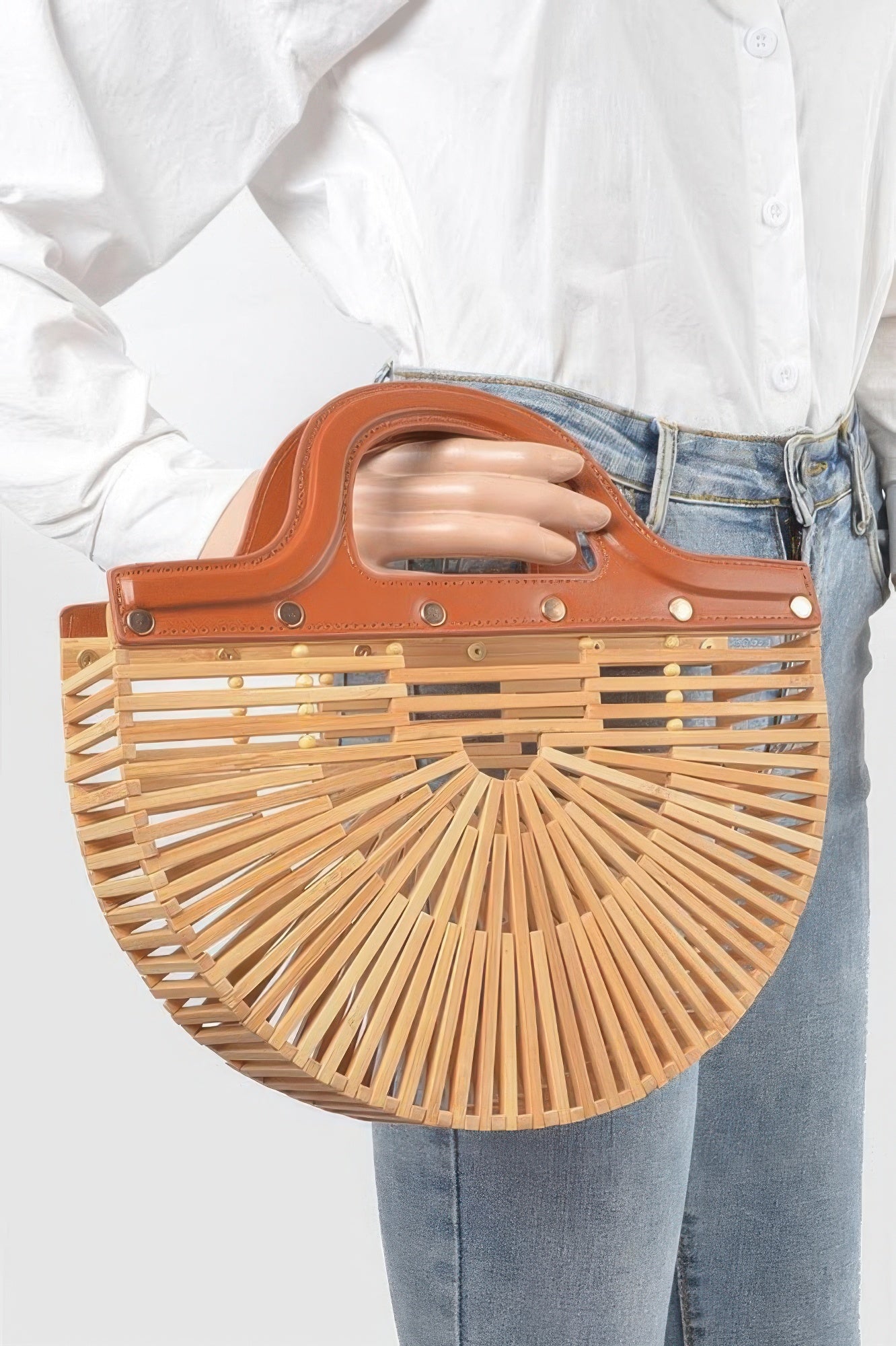 Bamboo top-handle bag worn on arm; caramel handle, slatted natural basket with snaps