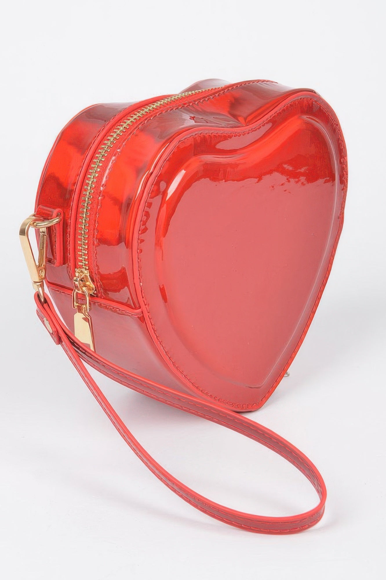 Red heart-shaped crossbody bag with gold zipper, front view and slim wrist strap