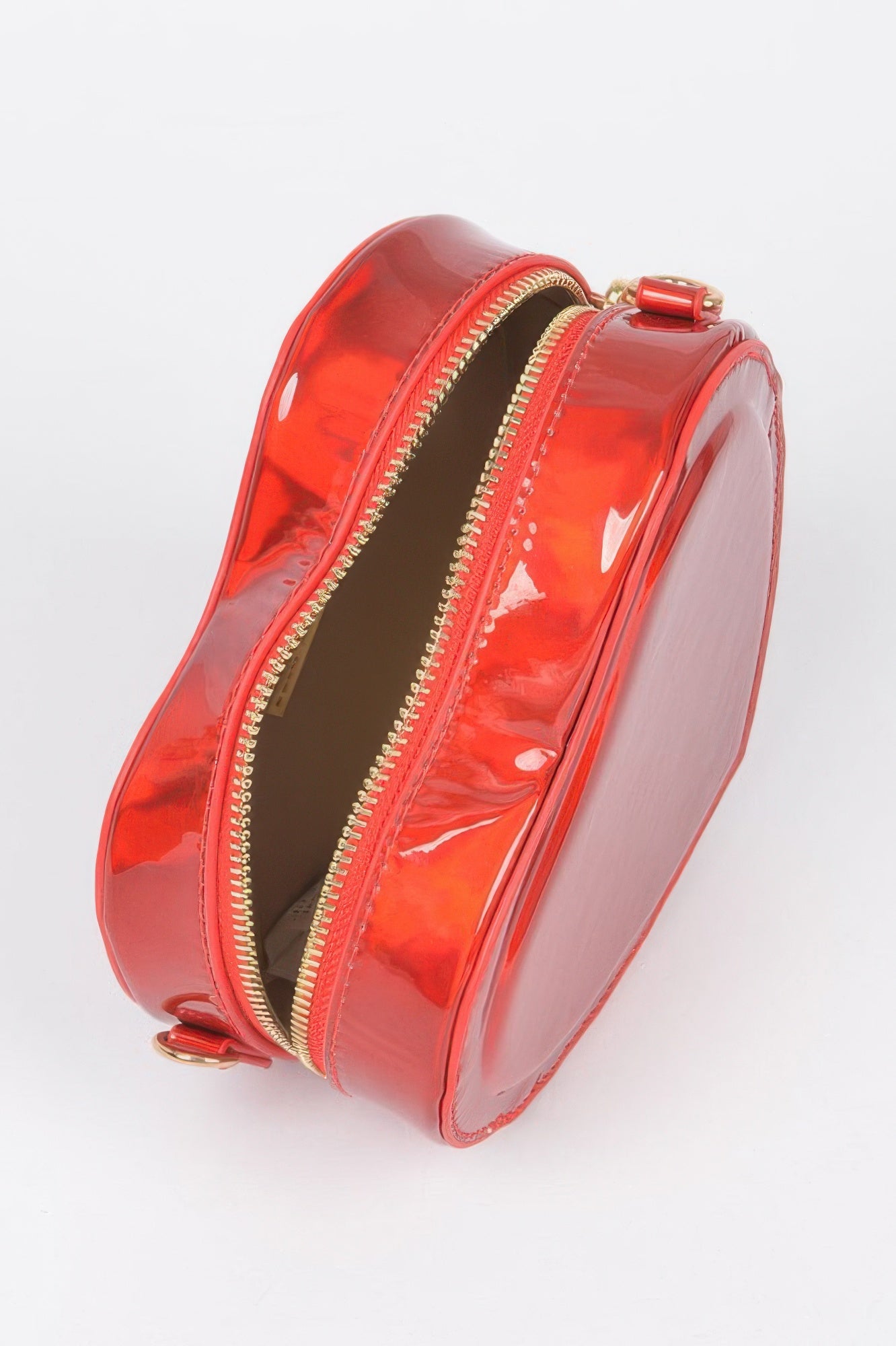 Red glossy heart crossbody bag showing open interior lining and zip closure