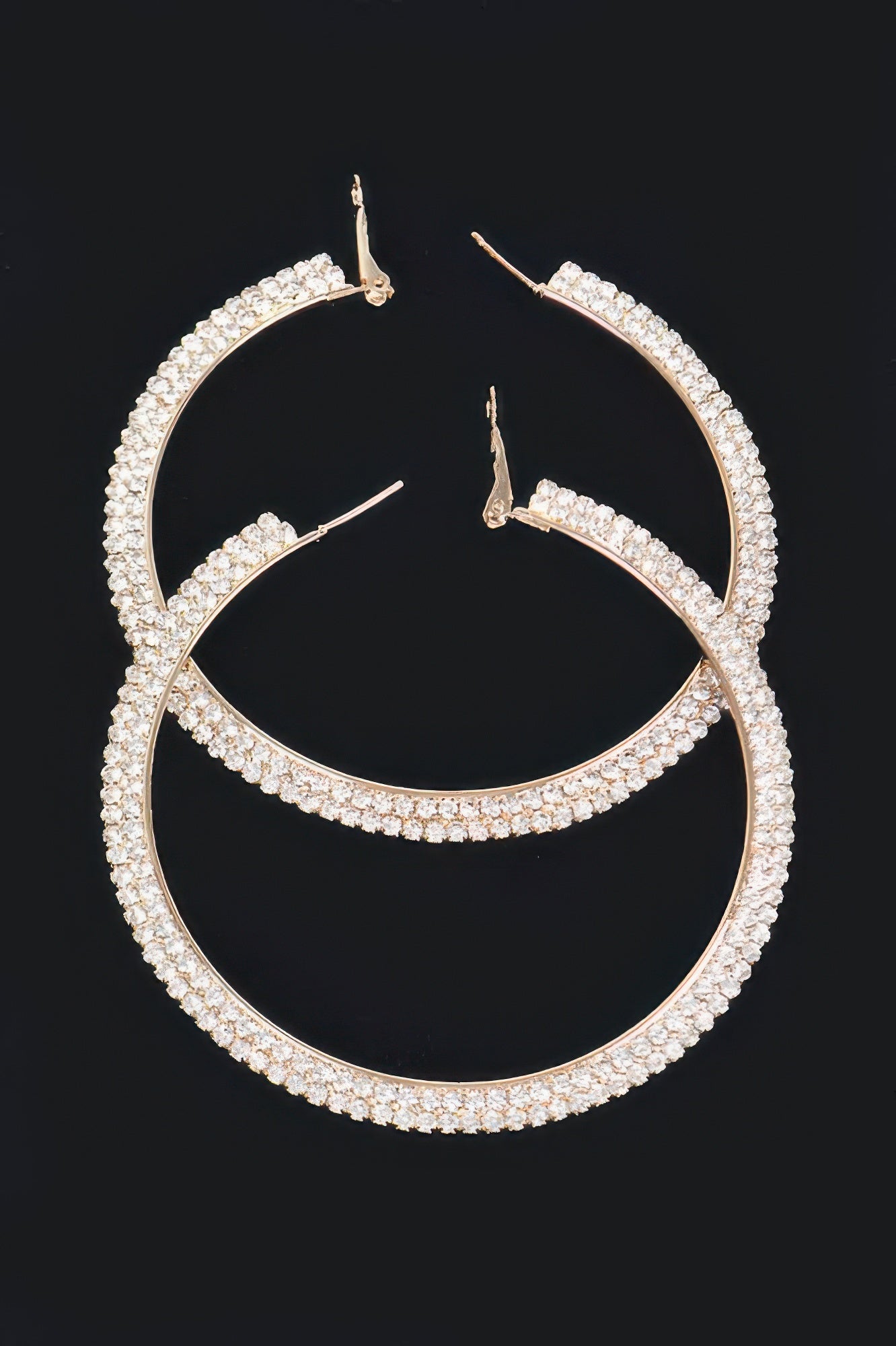 Gold-tone rhinestone hoop earrings with clear stones, full curved hoop design