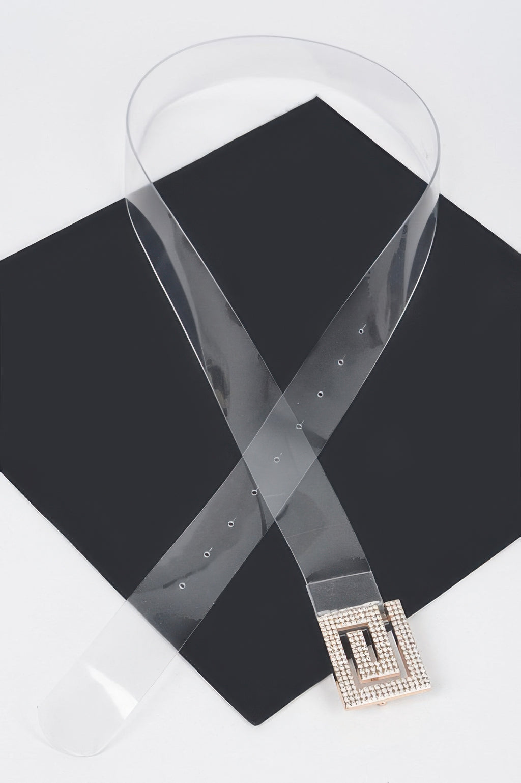 Clear vegan belt with square rhinestone buckle on dark fabric