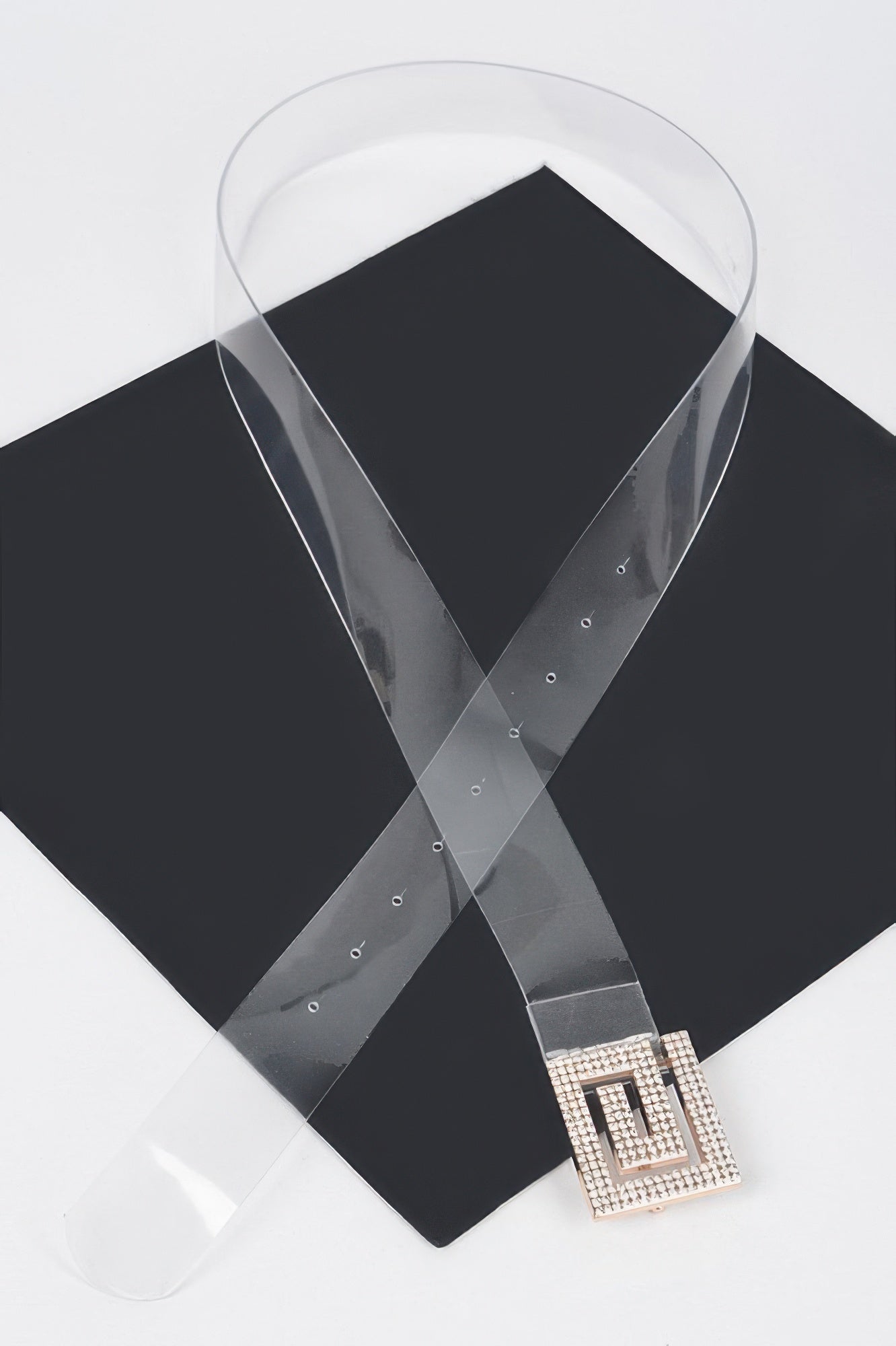 Clear vegan belt with square rhinestone buckle on dark fabric