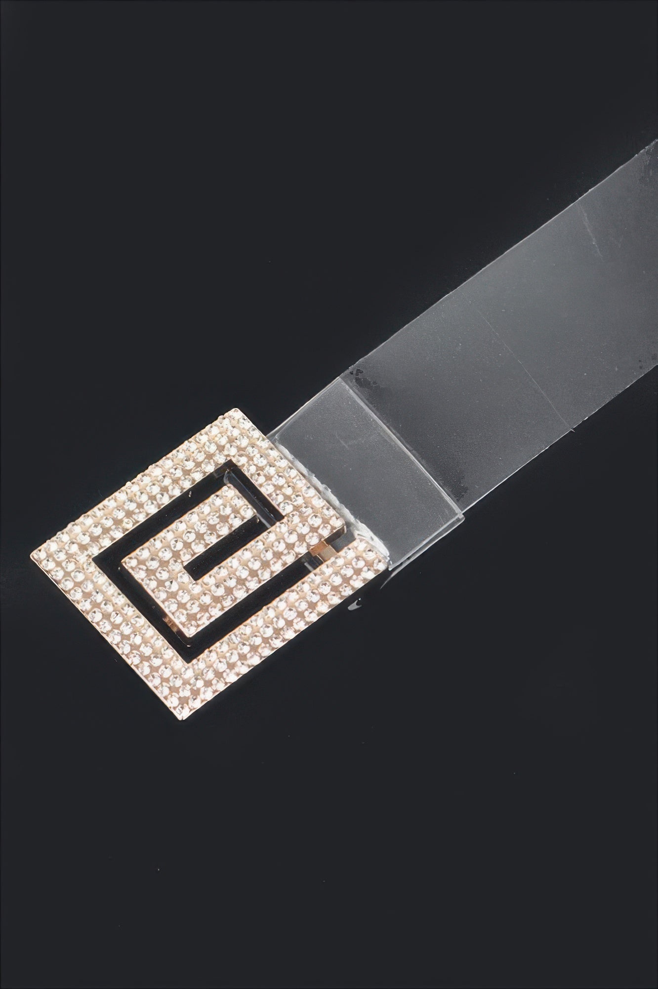 Close-up: clear vegan belt strap with square rhinestone buckle fastening