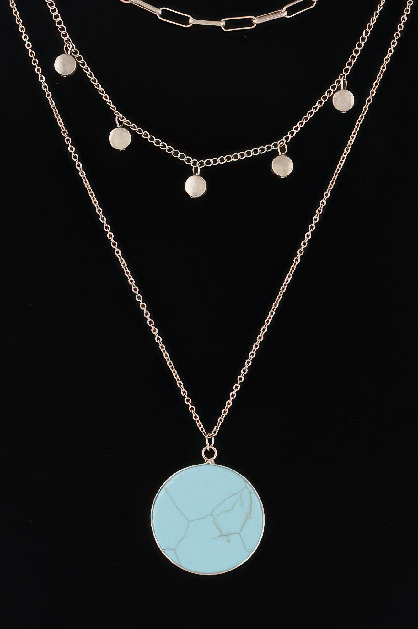 Layered gold chain necklace with turquoise round pendant and small disc charms