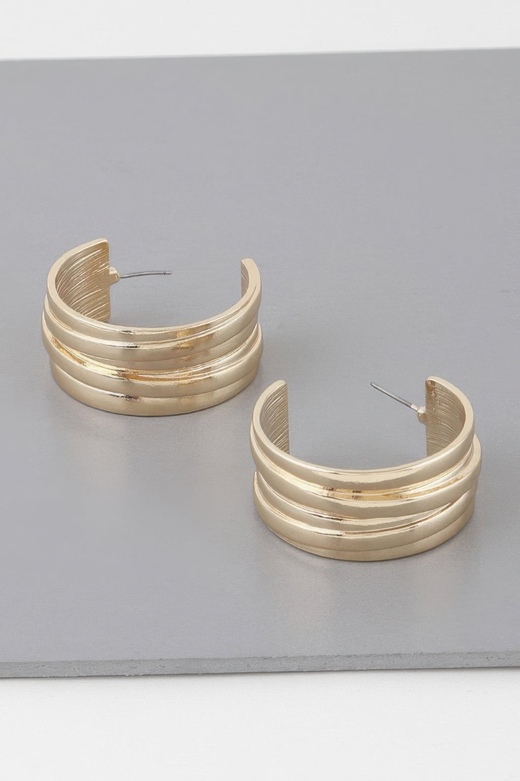 Gold multi-layer hoop earrings with ribbed bands, hinged posts