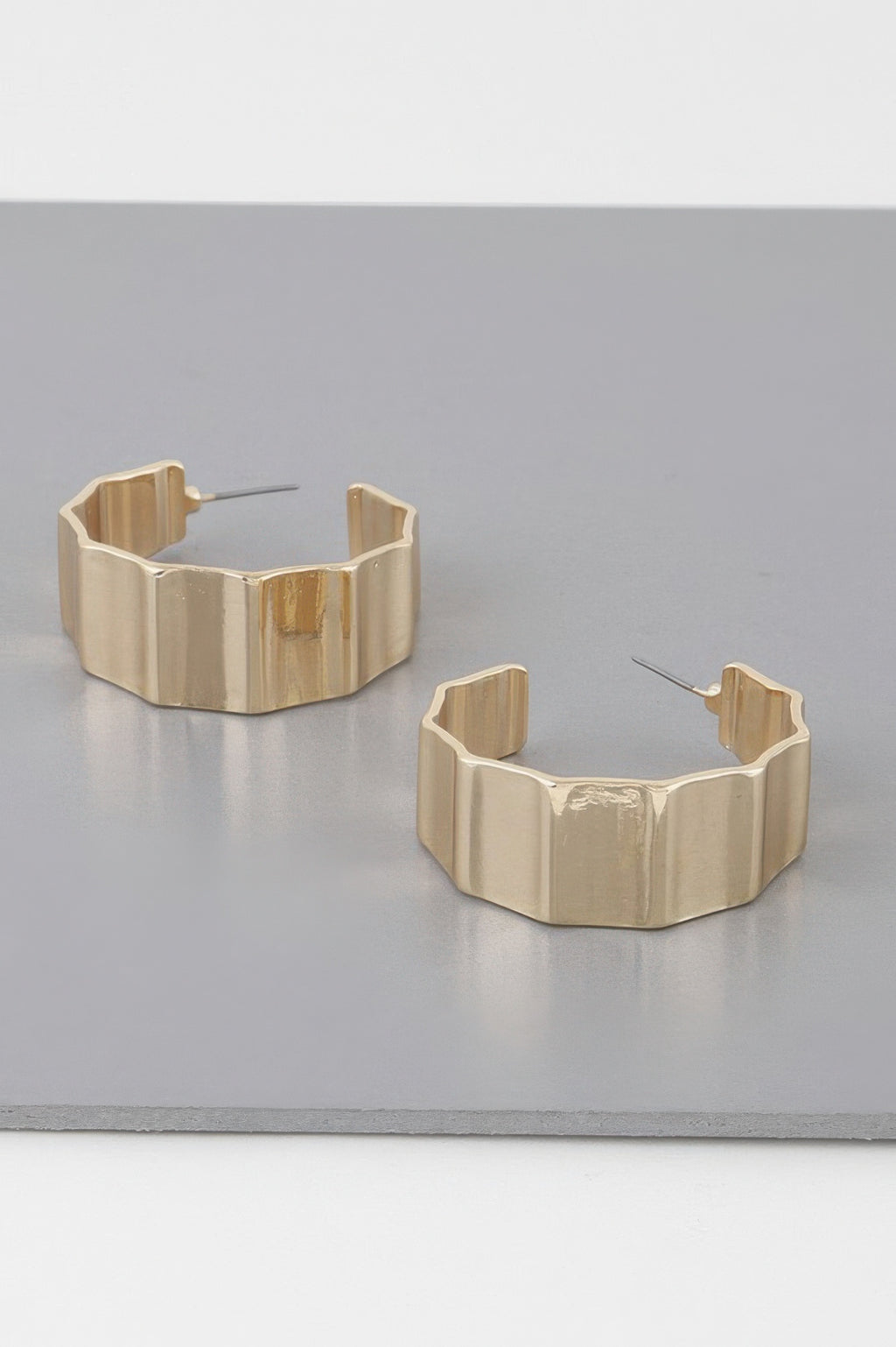 Gold metal ribbed hoop earrings, chunky curved band with open back