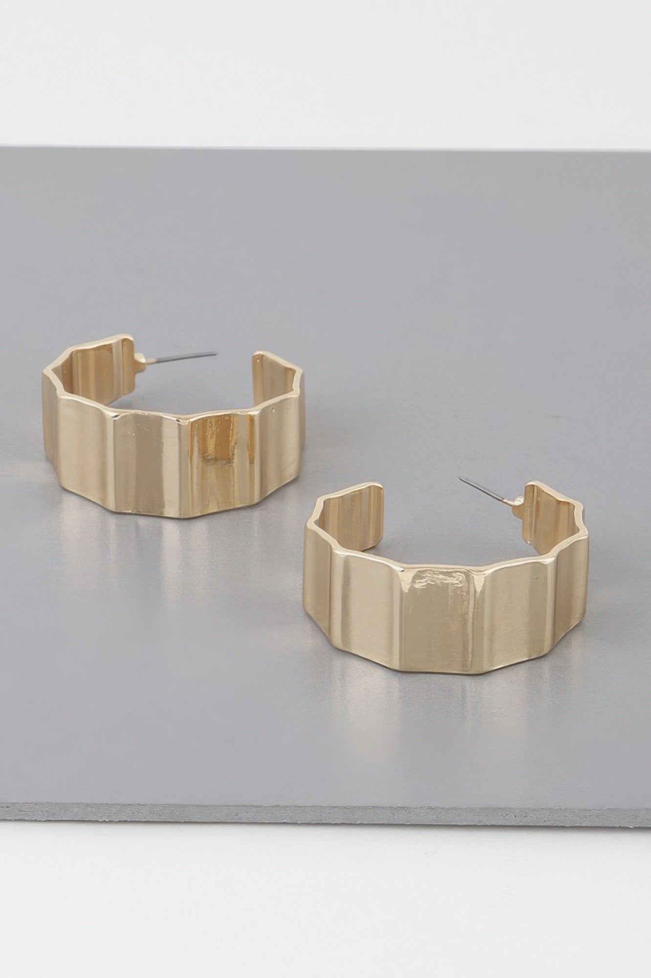 Gold metal ribbed hoop earrings, chunky curved band with open back