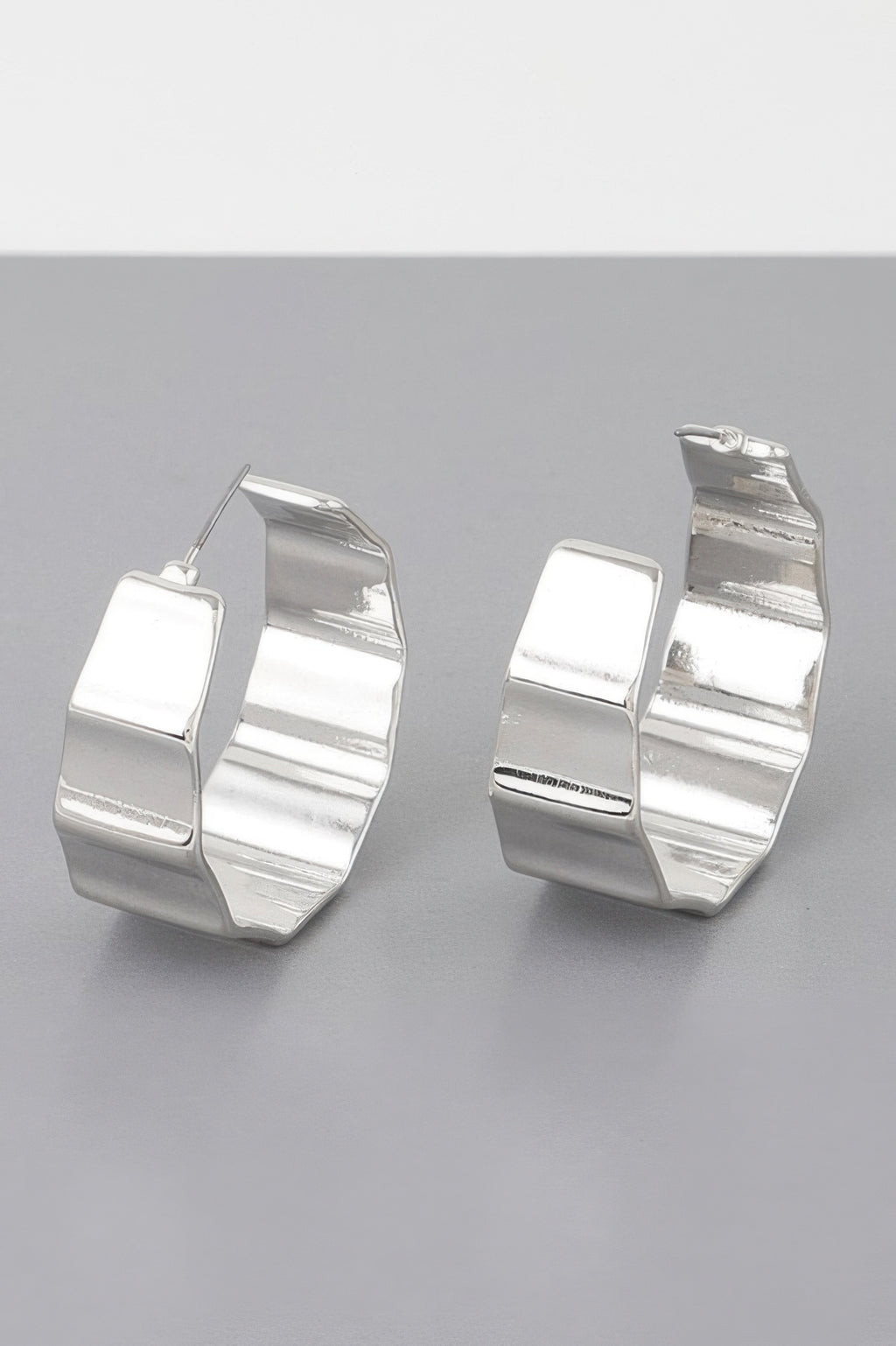 Silver metal ribbed hoop earrings, reflective curved hoops with small hinge posts