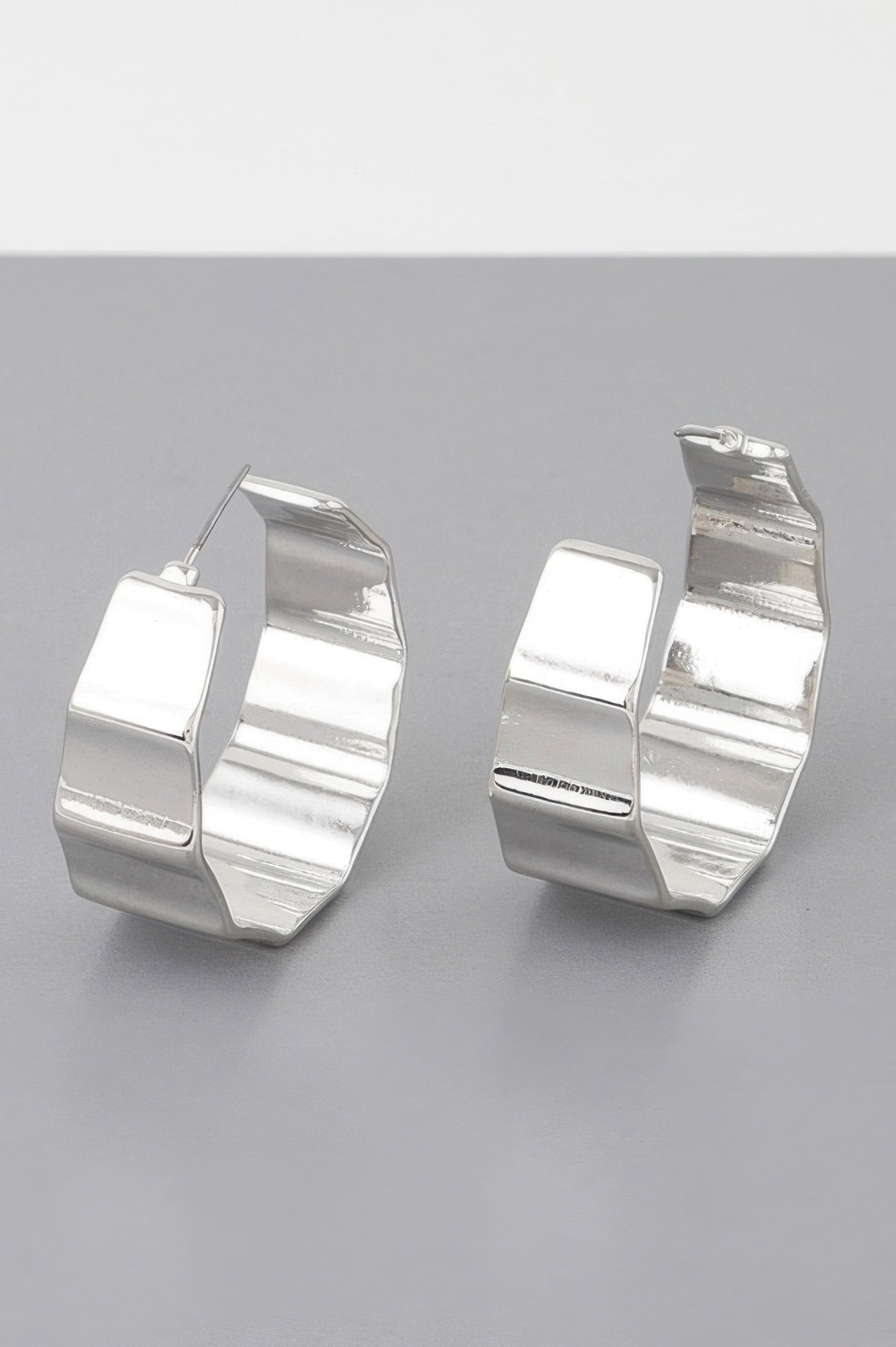 Silver metal ribbed hoop earrings, reflective curved hoops with small hinge posts