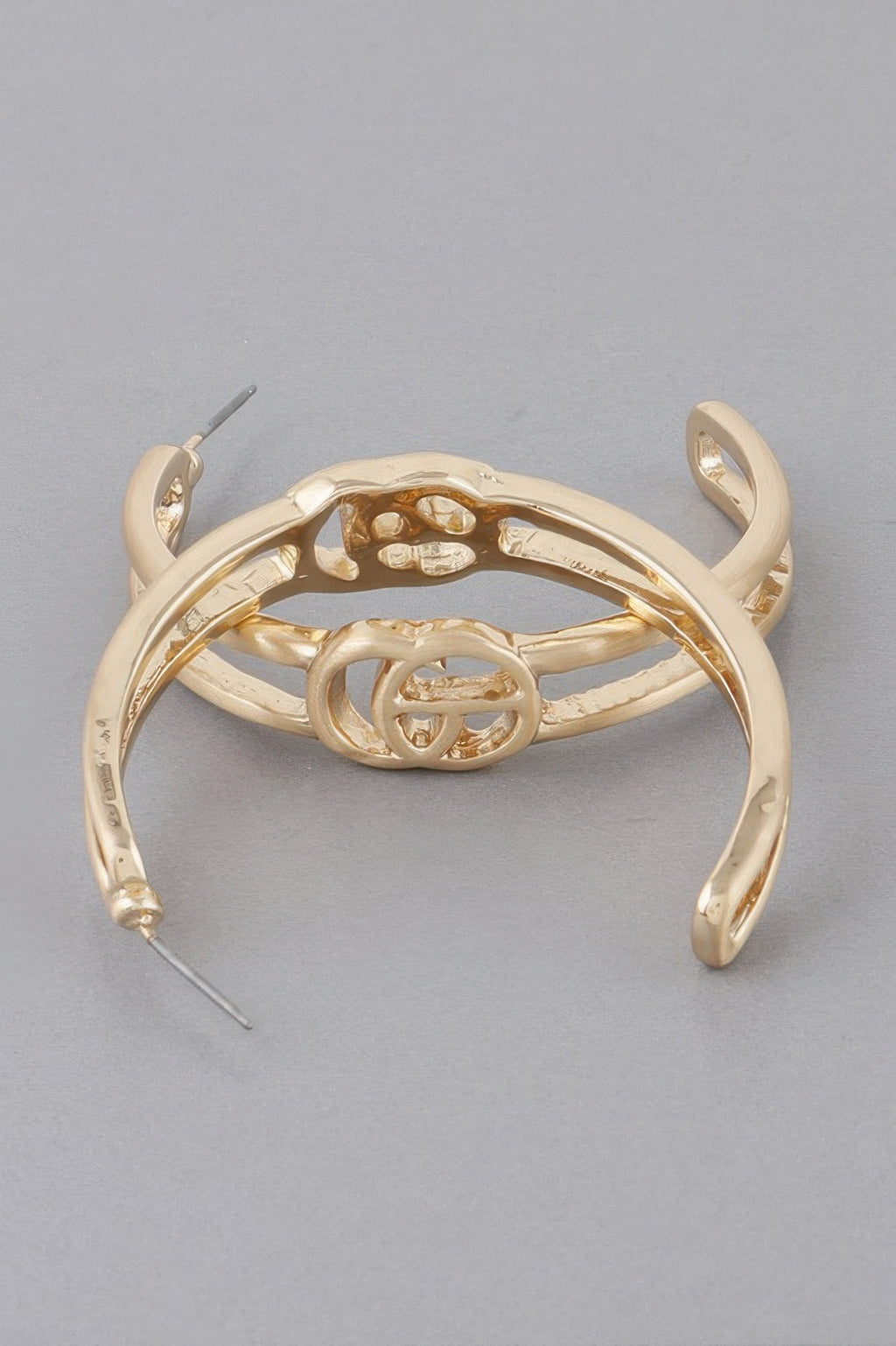Gold Cg hoop earrings, close-up of inner emblem and curved hoop.