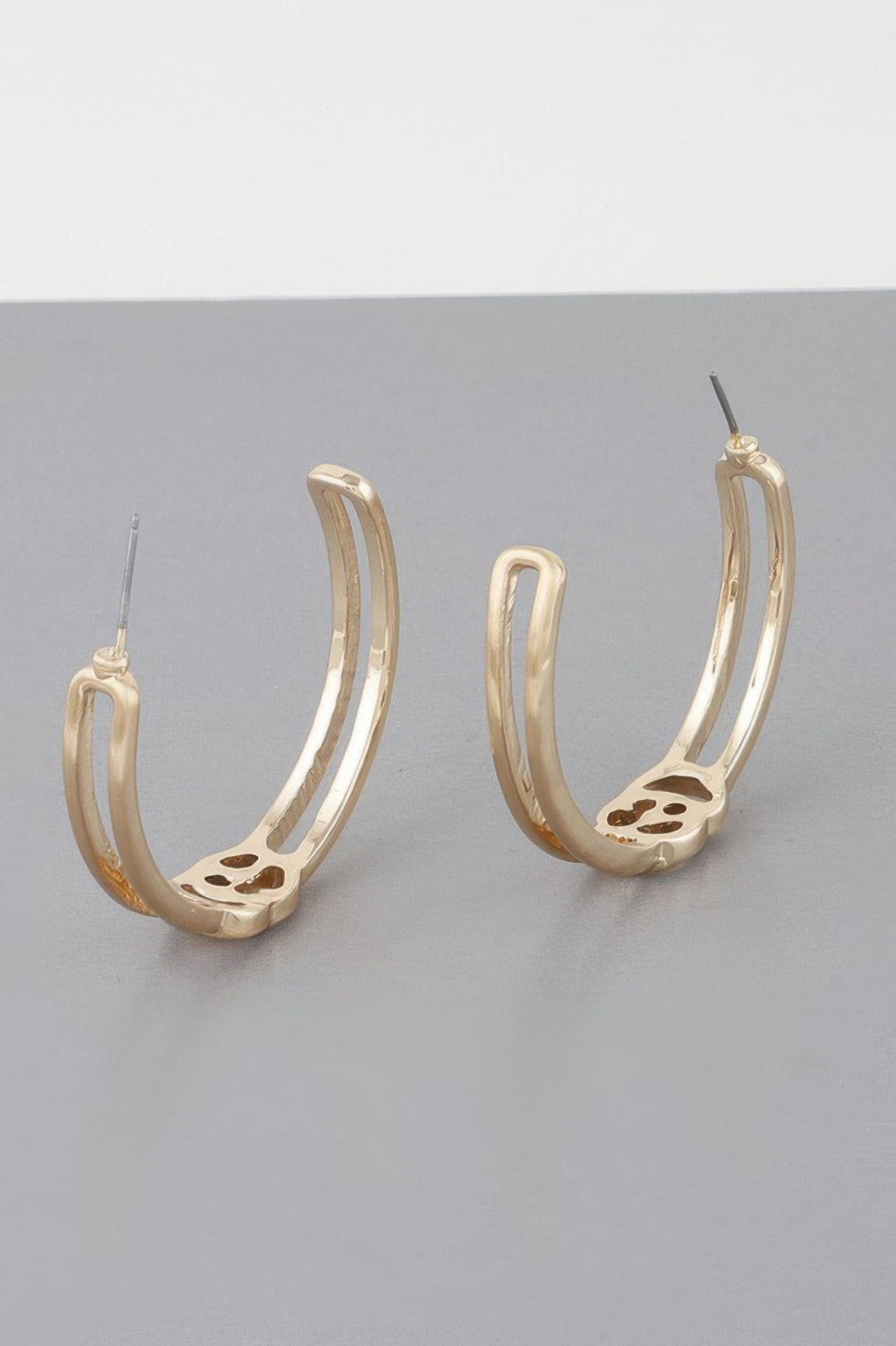 Gold hoop earrings with cutout pattern on inner front, side view.