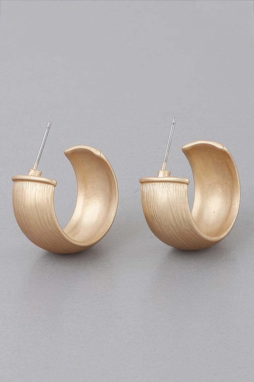Pair of gold-tone scraped bulky hoop earrings with open back and clear stud pins