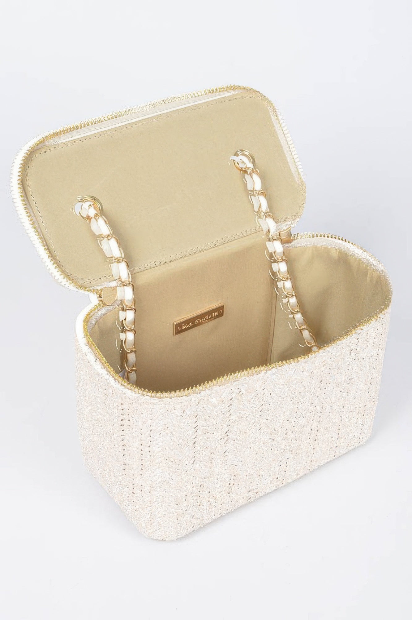 Open faux straw cosmetic case with beige lining, gold hardware, and zip closure