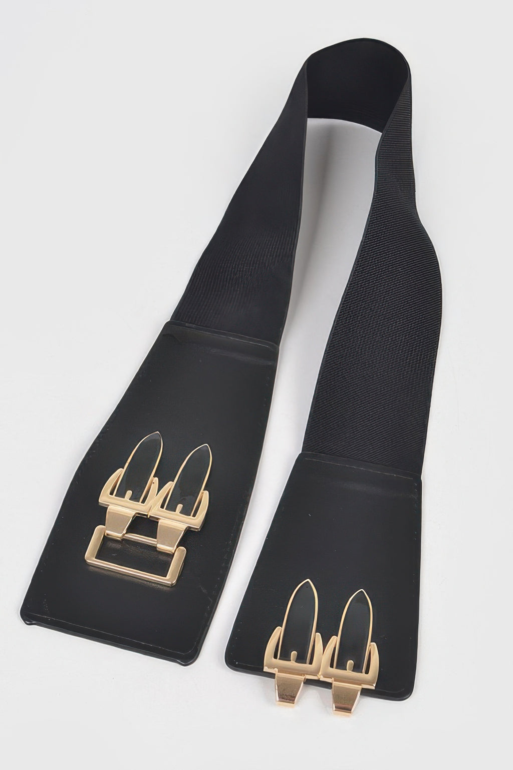 Black belt straps with gold rectangular buckle detail, flat lay