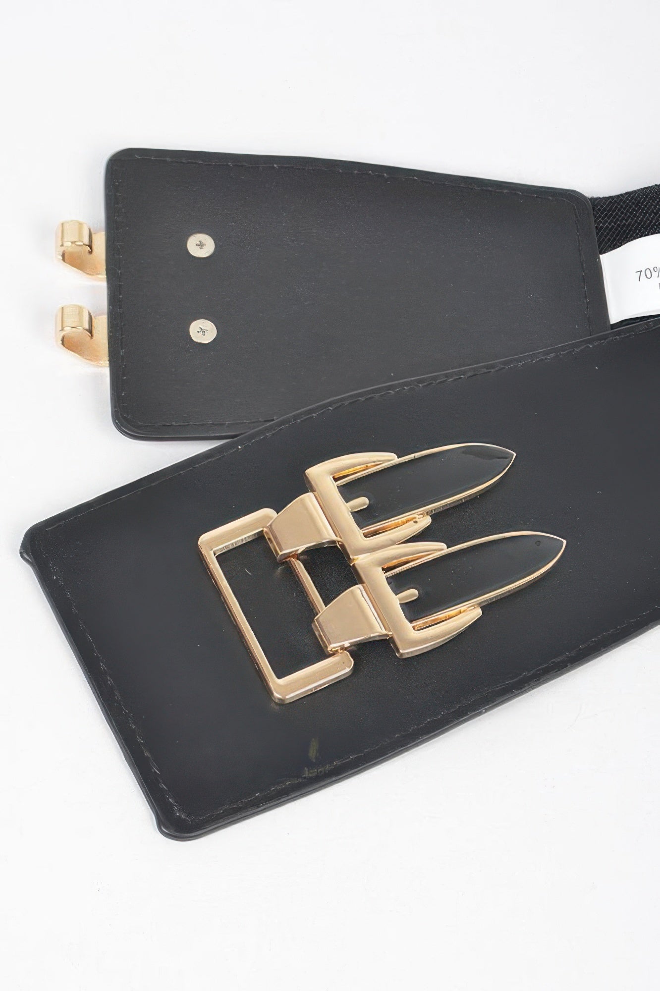 Black belt end tabs and gold buckle hardware, close-up