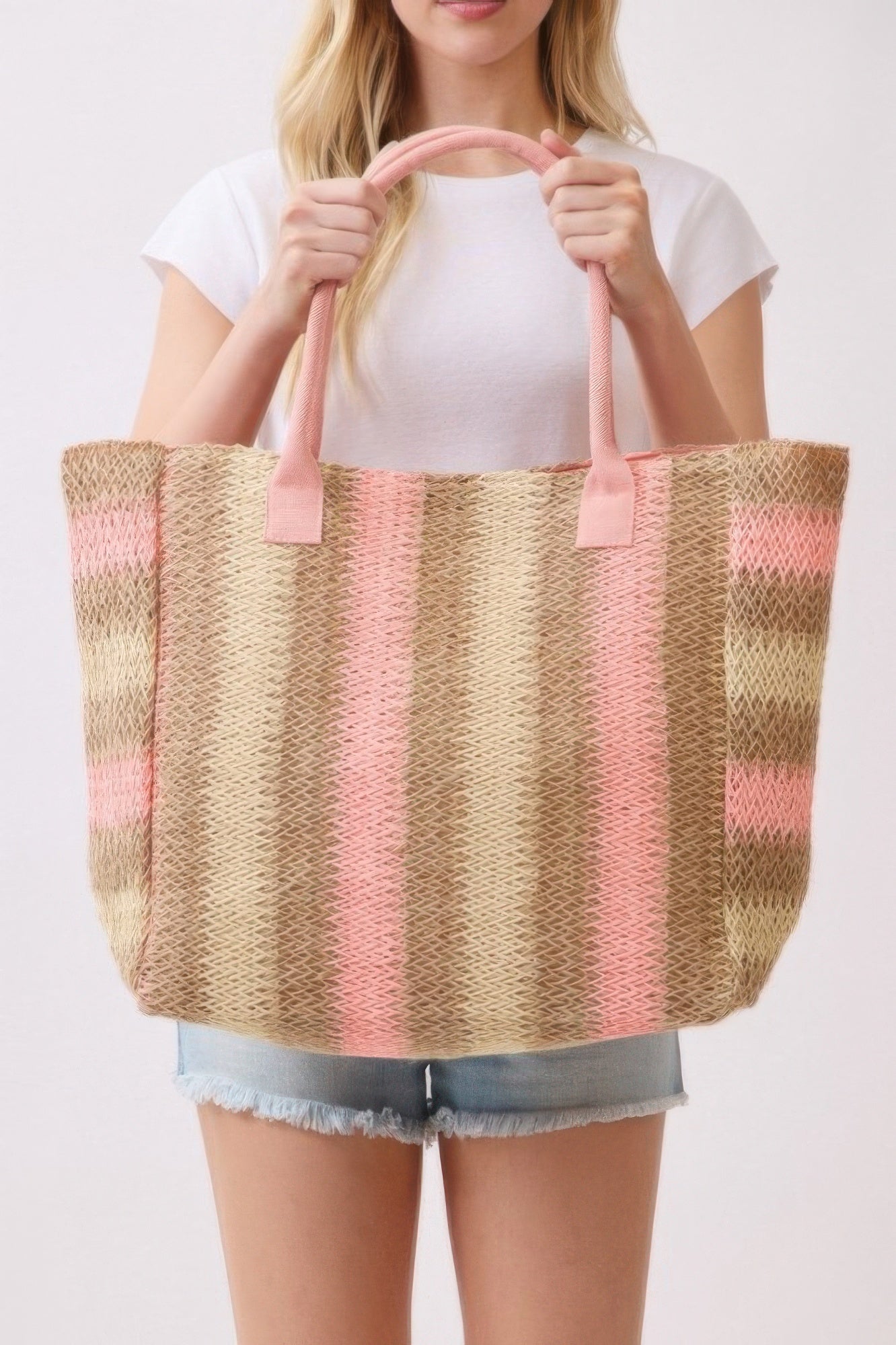 Pink rope handles on striped straw tote bag in natural brown and pink