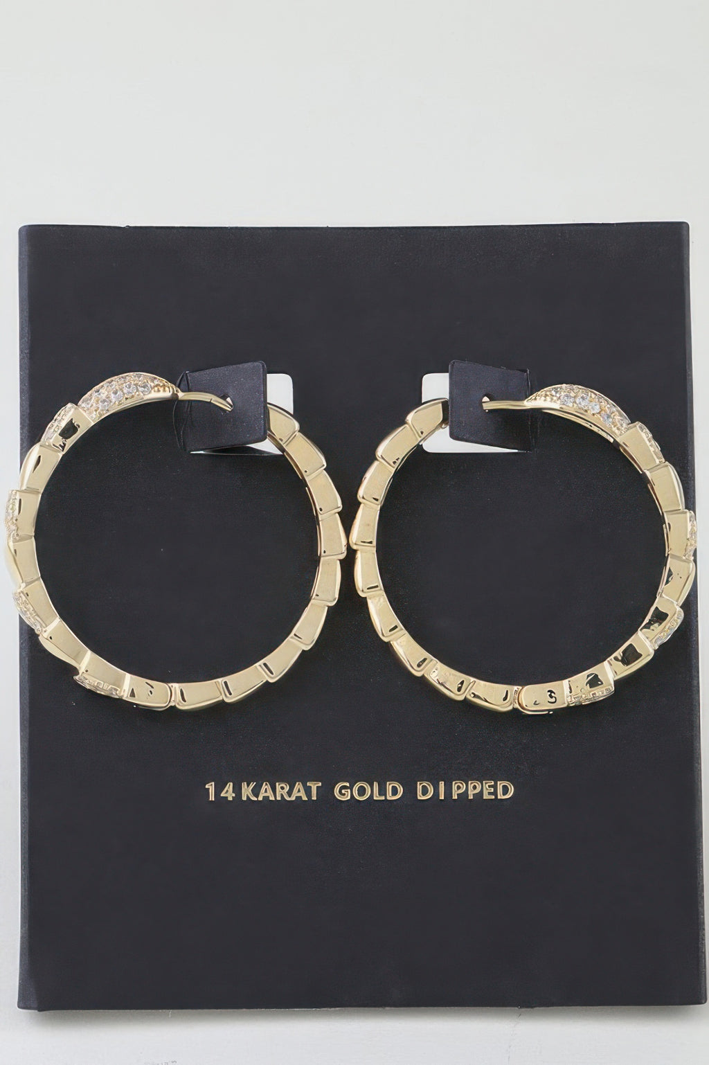 Gold snake-scale hoop earrings with crystal pavé accents, hinged hoop design
