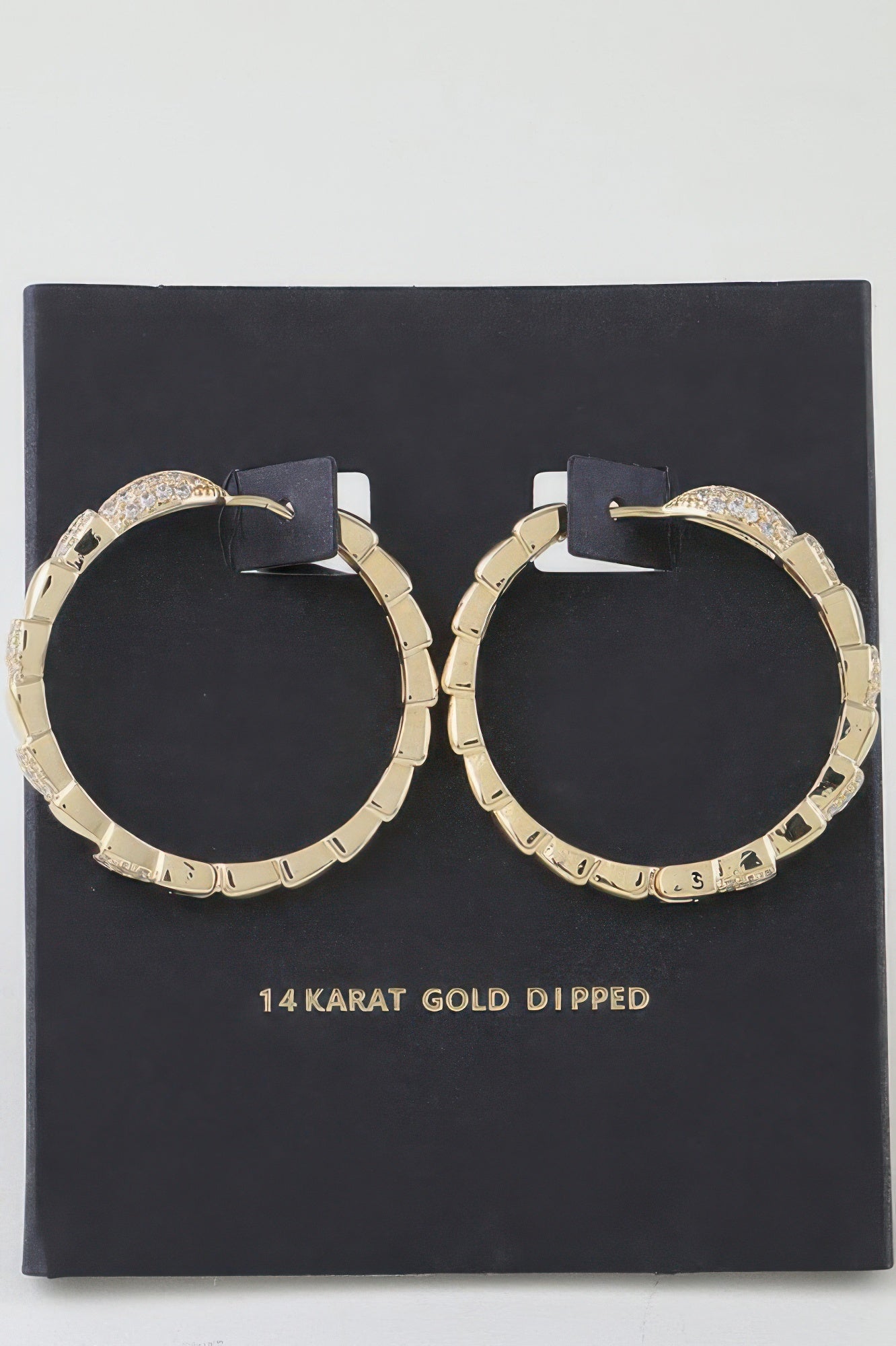Gold snake-scale hoop earrings with crystal pavé accents, hinged hoop design