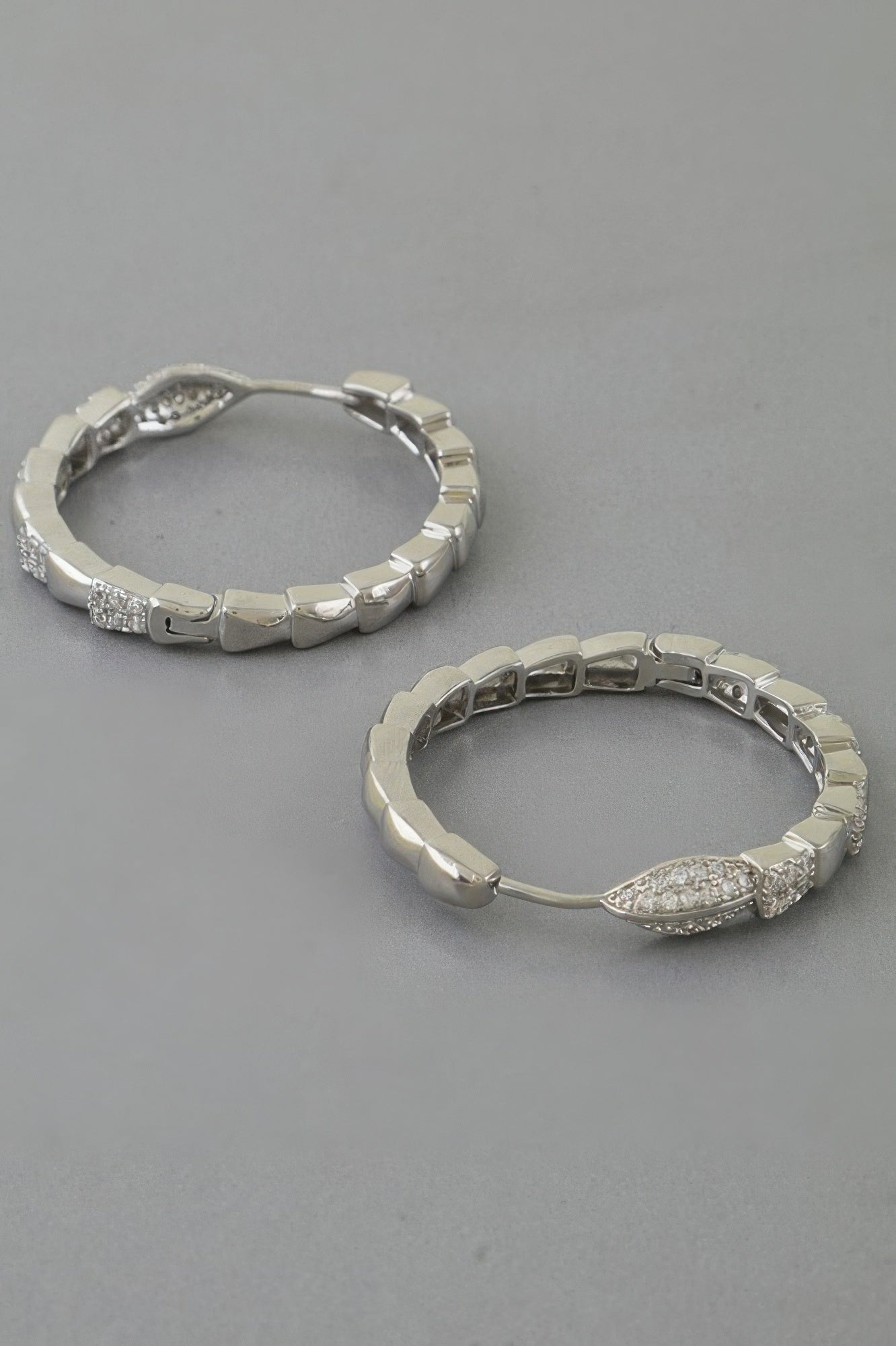 Silver snake-scale hoop earrings with pave crystal accents and hinged hoop posts