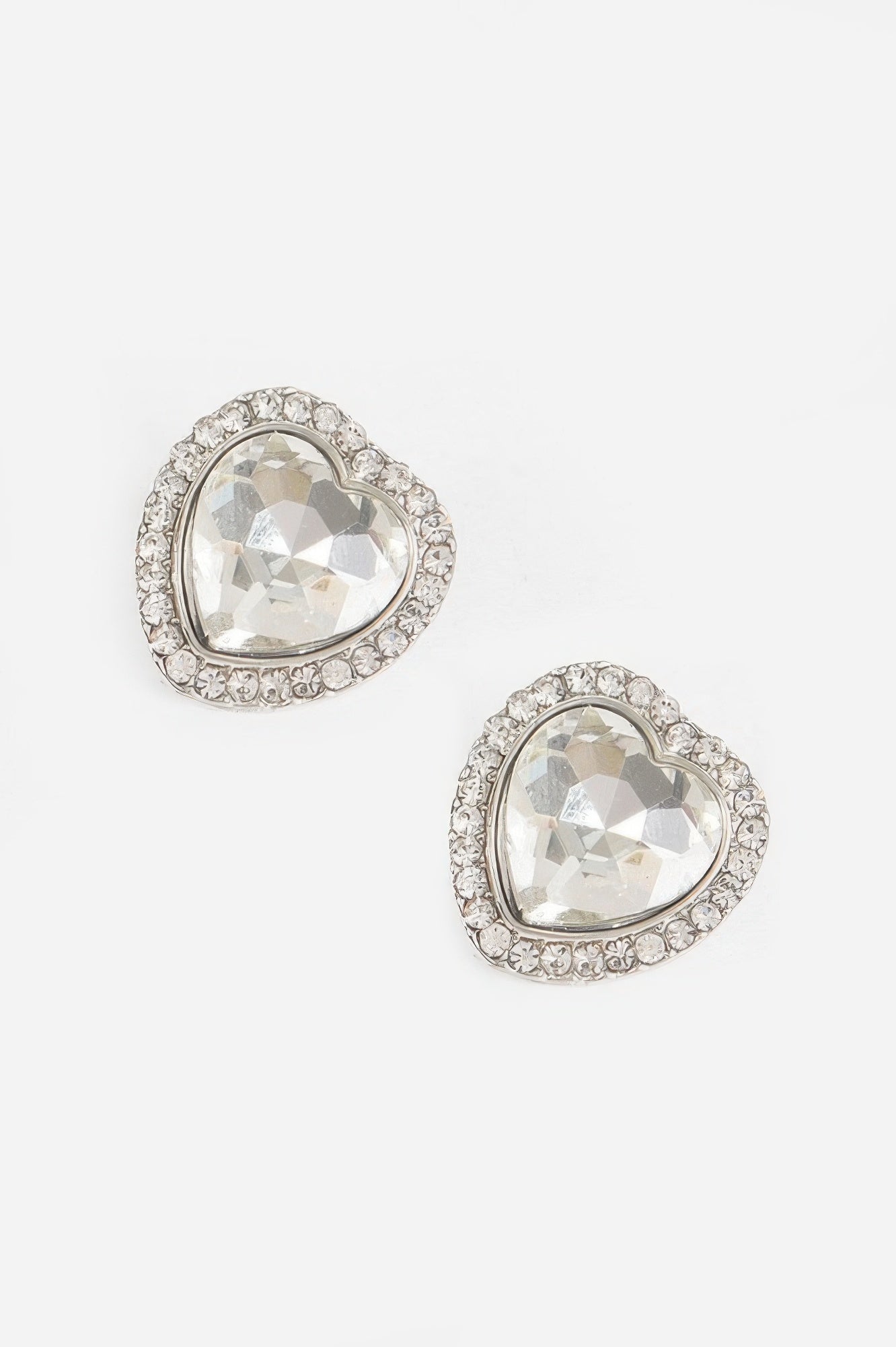 Heart-shaped stone earrings with clear/white gem and silver-tone crystal border