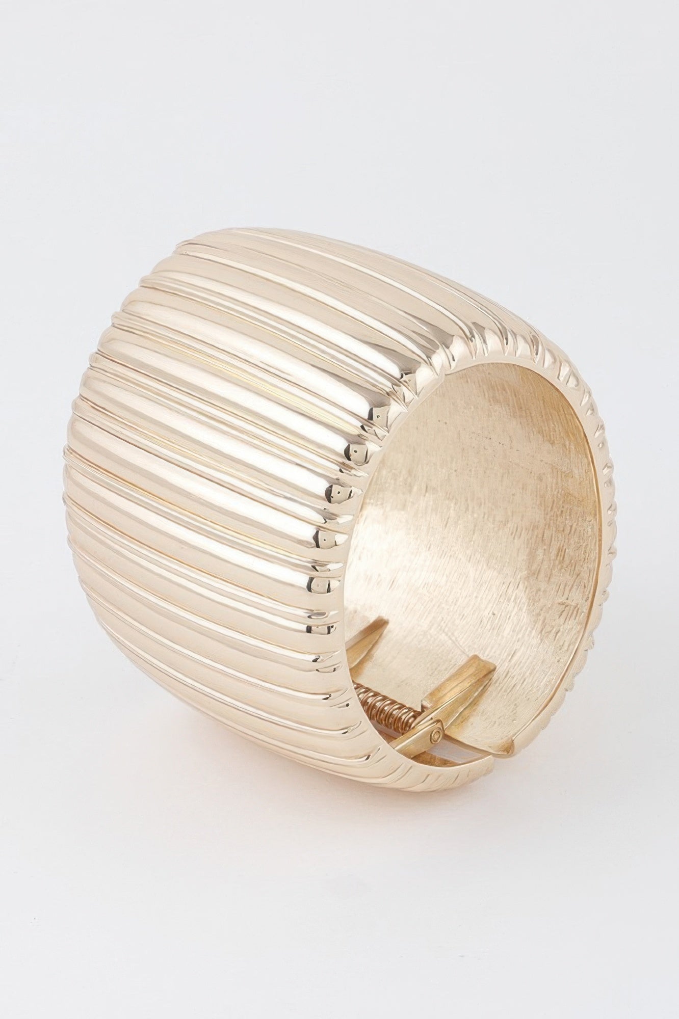 Gold ribbed cuff bracelet, side view with hinge closure.