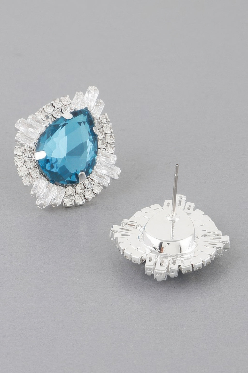 Jeweled teardrop crystal stud earrings in aqua blue with silver-toned halo and backs