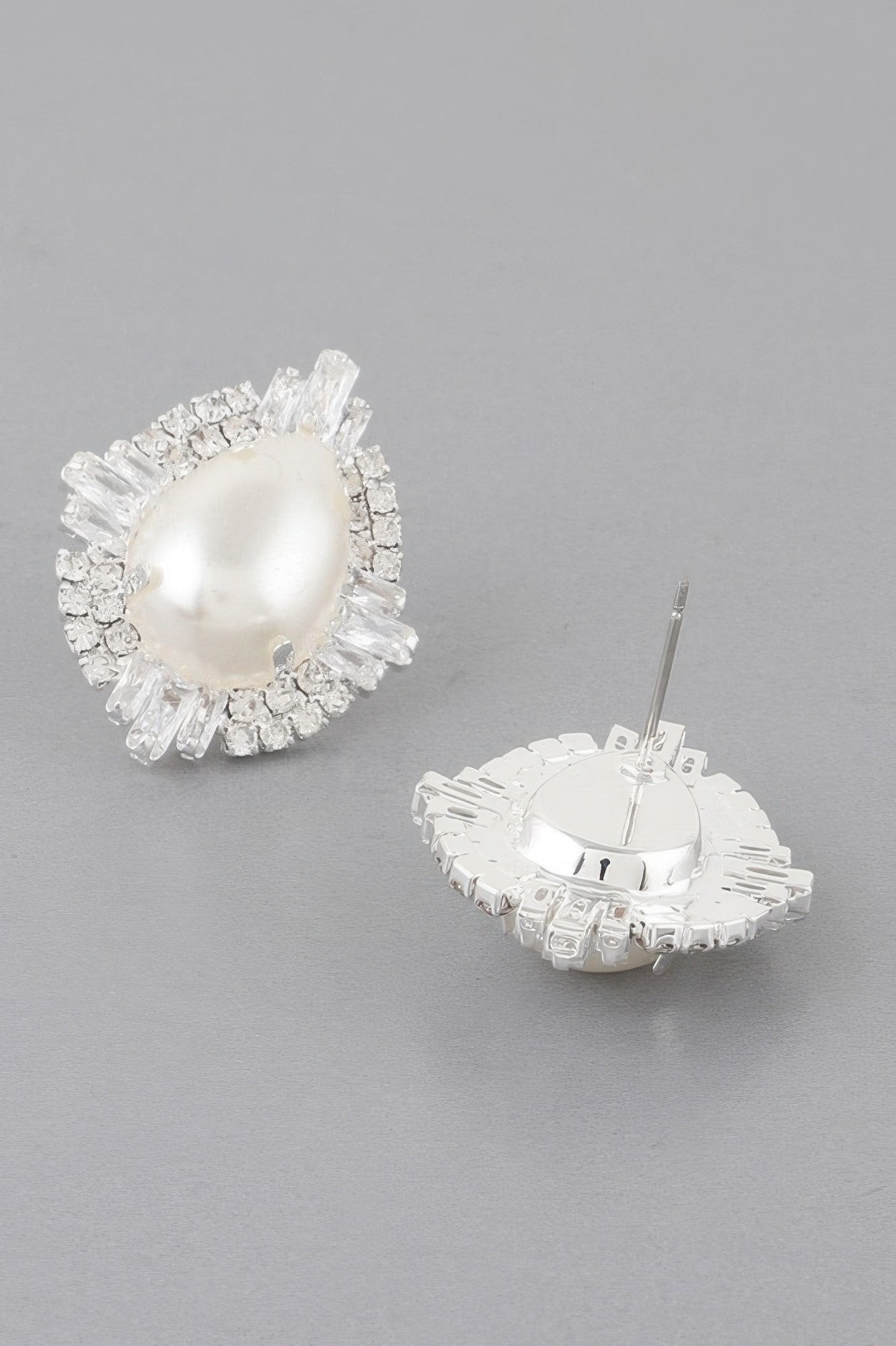 Clear teardrop crystal stud earrings with silver-toned halo; earring backs visible