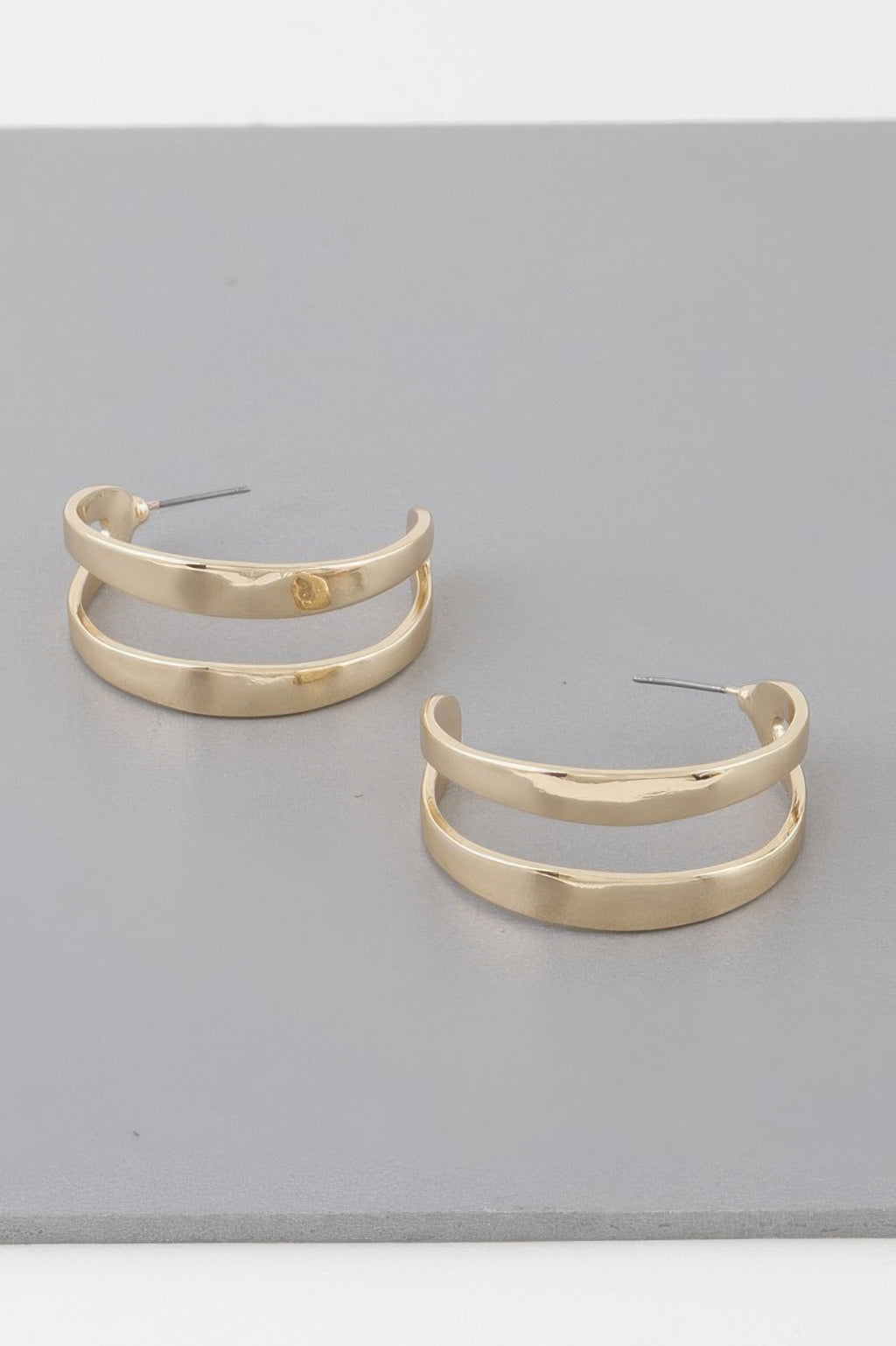 Gold melted open hoop earrings with curved hammered hoops