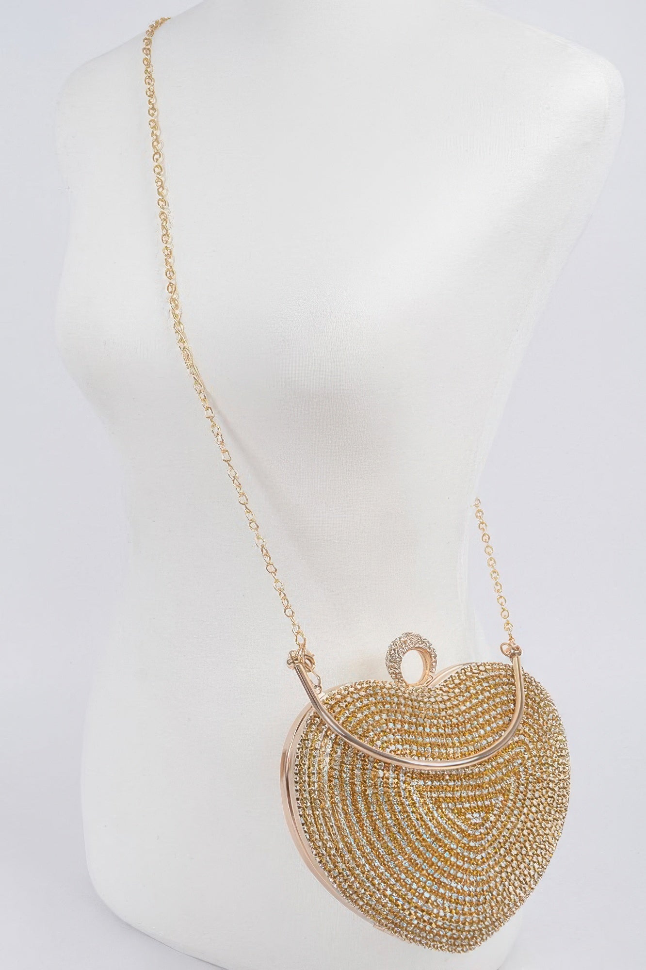 Gold-tone rhinestone heart crossbody clutch with long chain strap on mannequin