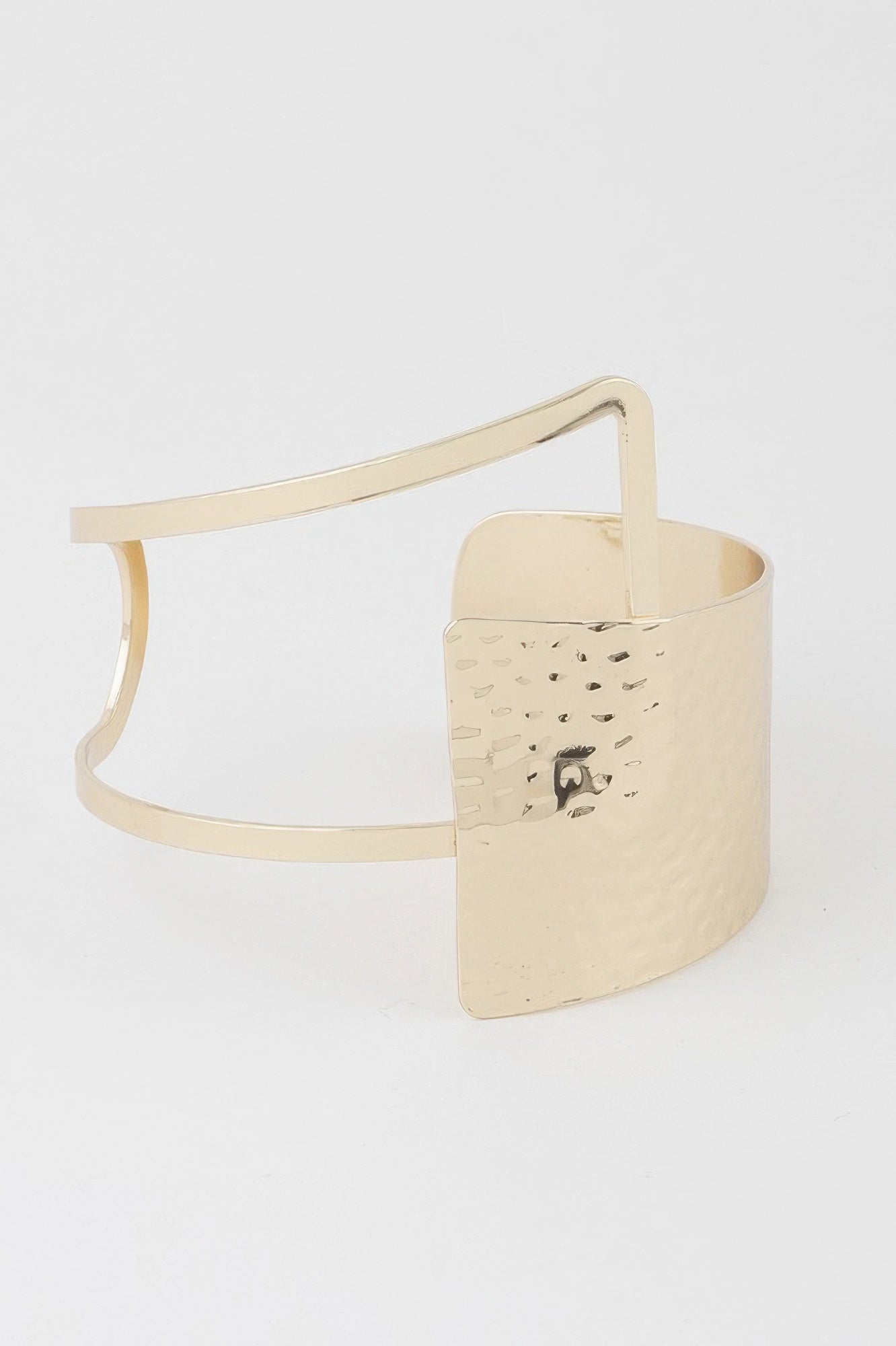 Gold cuff bracelet with open negative-space design and curved rectangle panel