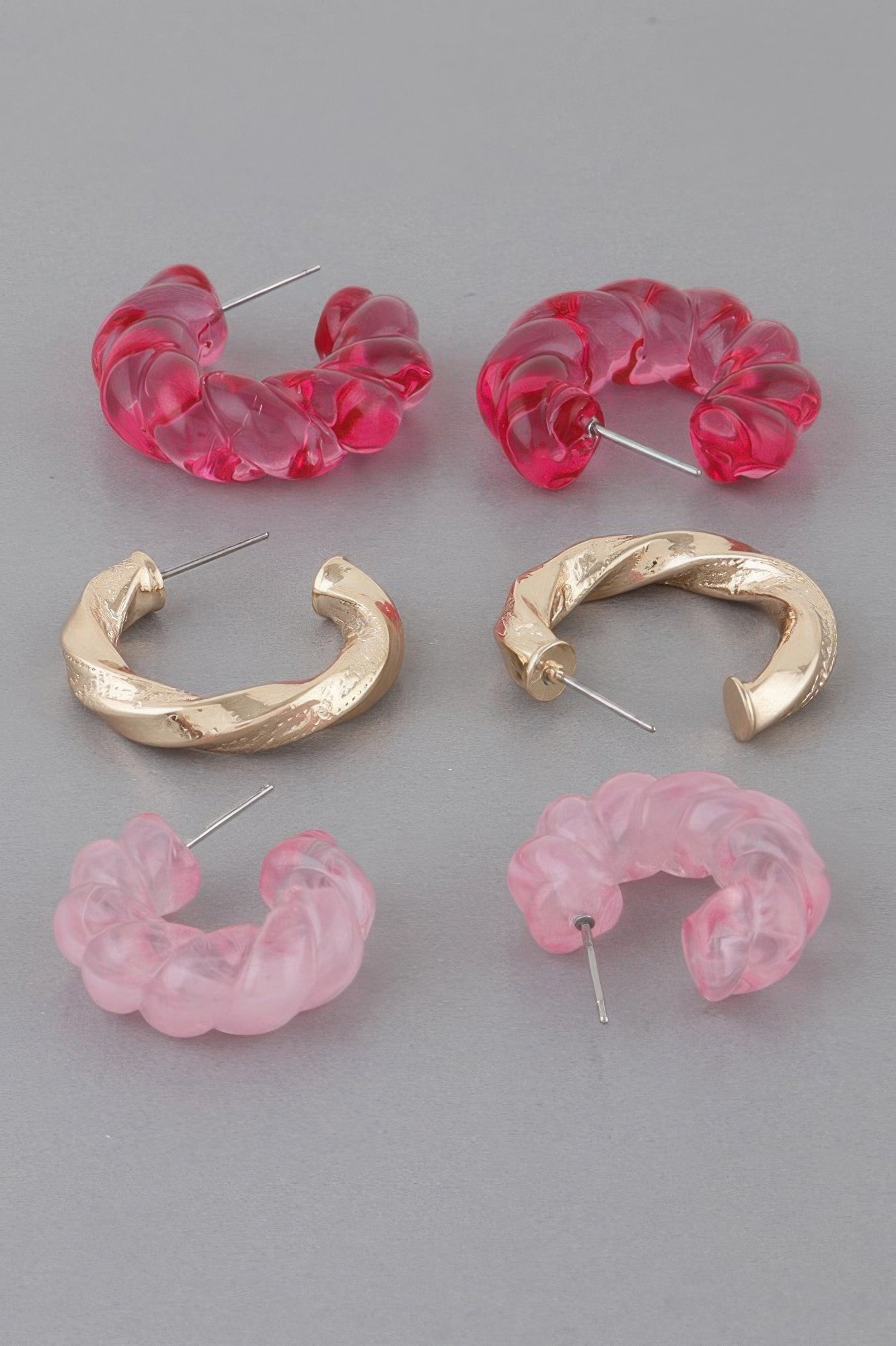Set of twisted hoop earrings in pink translucent and gold-tone finishes, 3 pairs