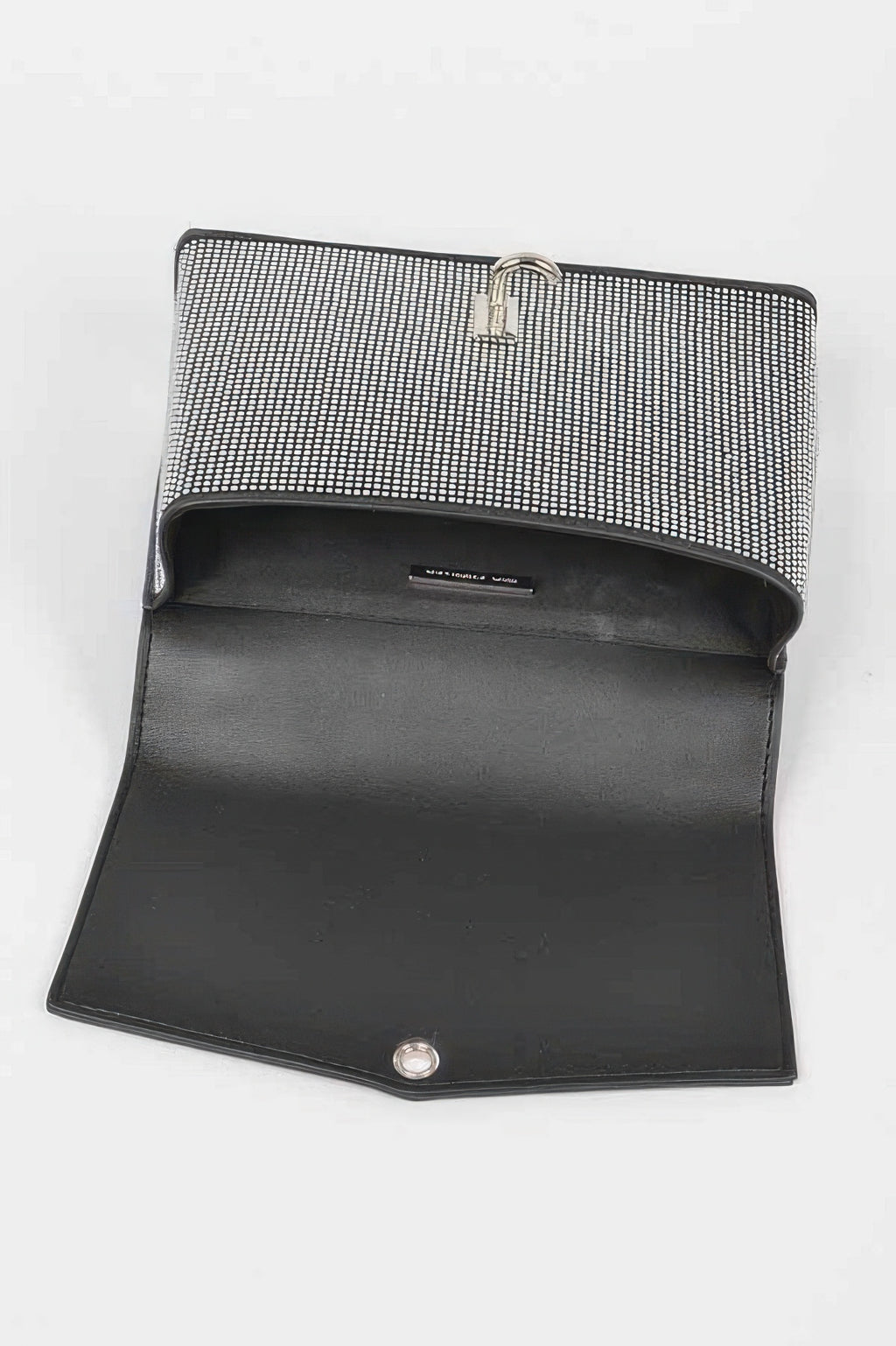 Rhinestone clutch opened to show dark interior lining and turn-lock clasp on flap.