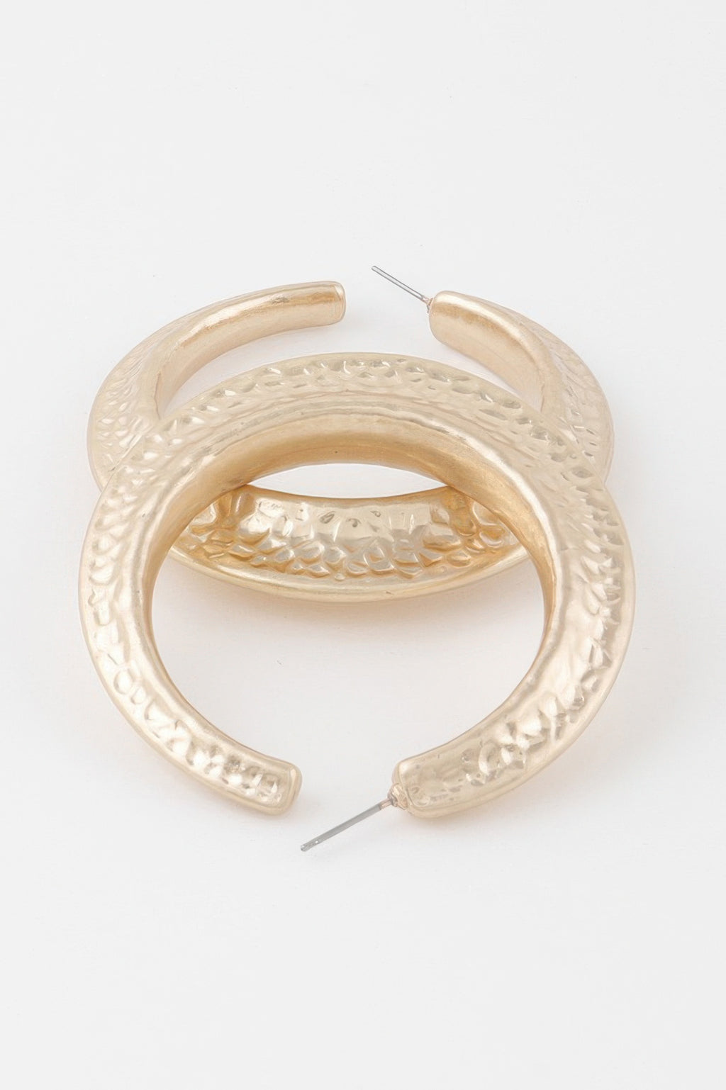 Scaled indent hoop earring close-up, gold-tone textured pattern