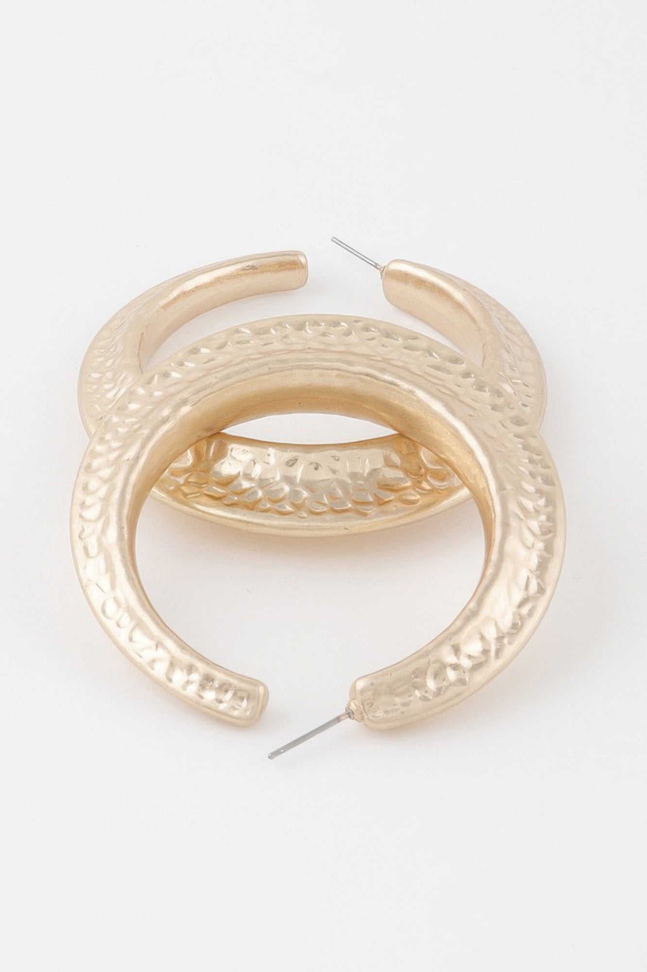 Scaled indent hoop earring close-up, gold-tone textured pattern