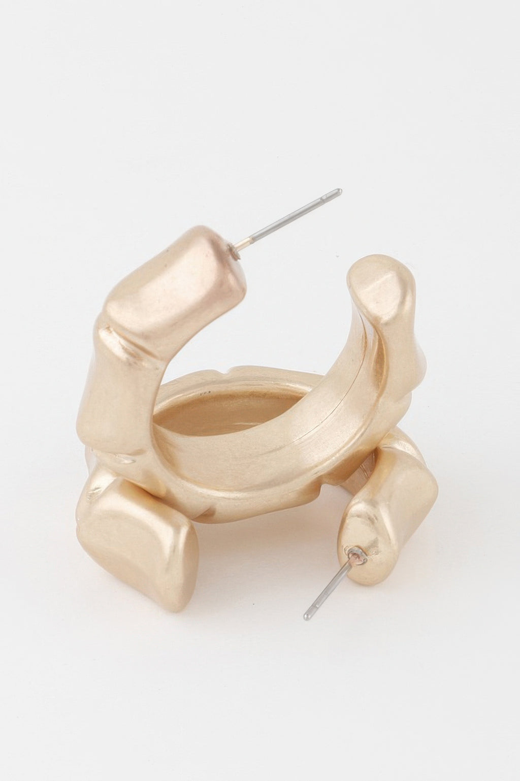 Close-up: gold skeleton-style hoop earrings with attached stud posts