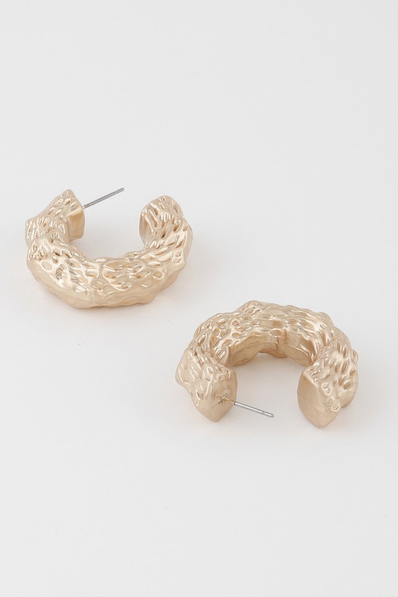 Abstract erosion hoop earrings, gold tone, side view with stud post