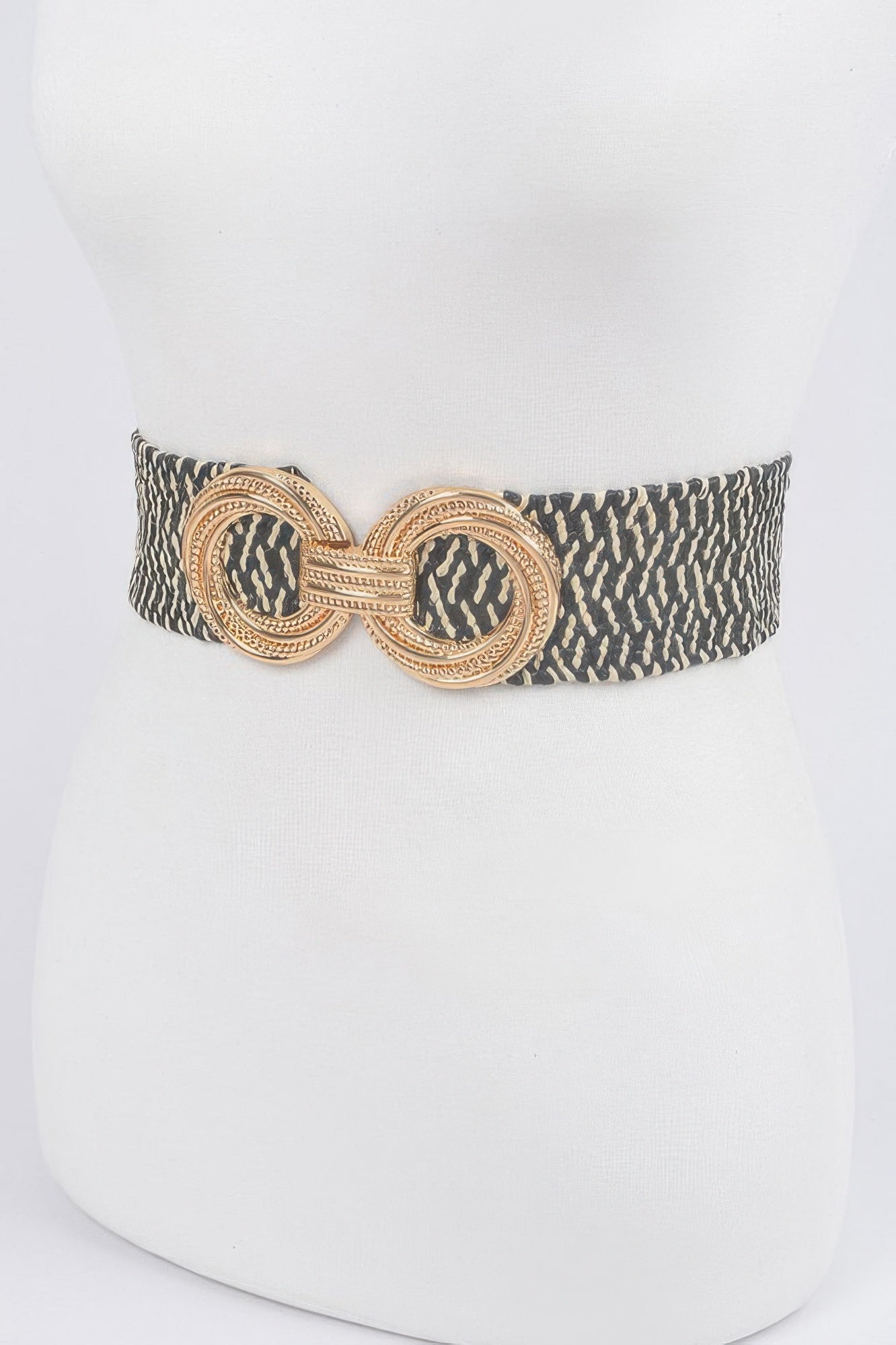 Dark patterned stretch waist belt with round filigree metal buckle, centered at front