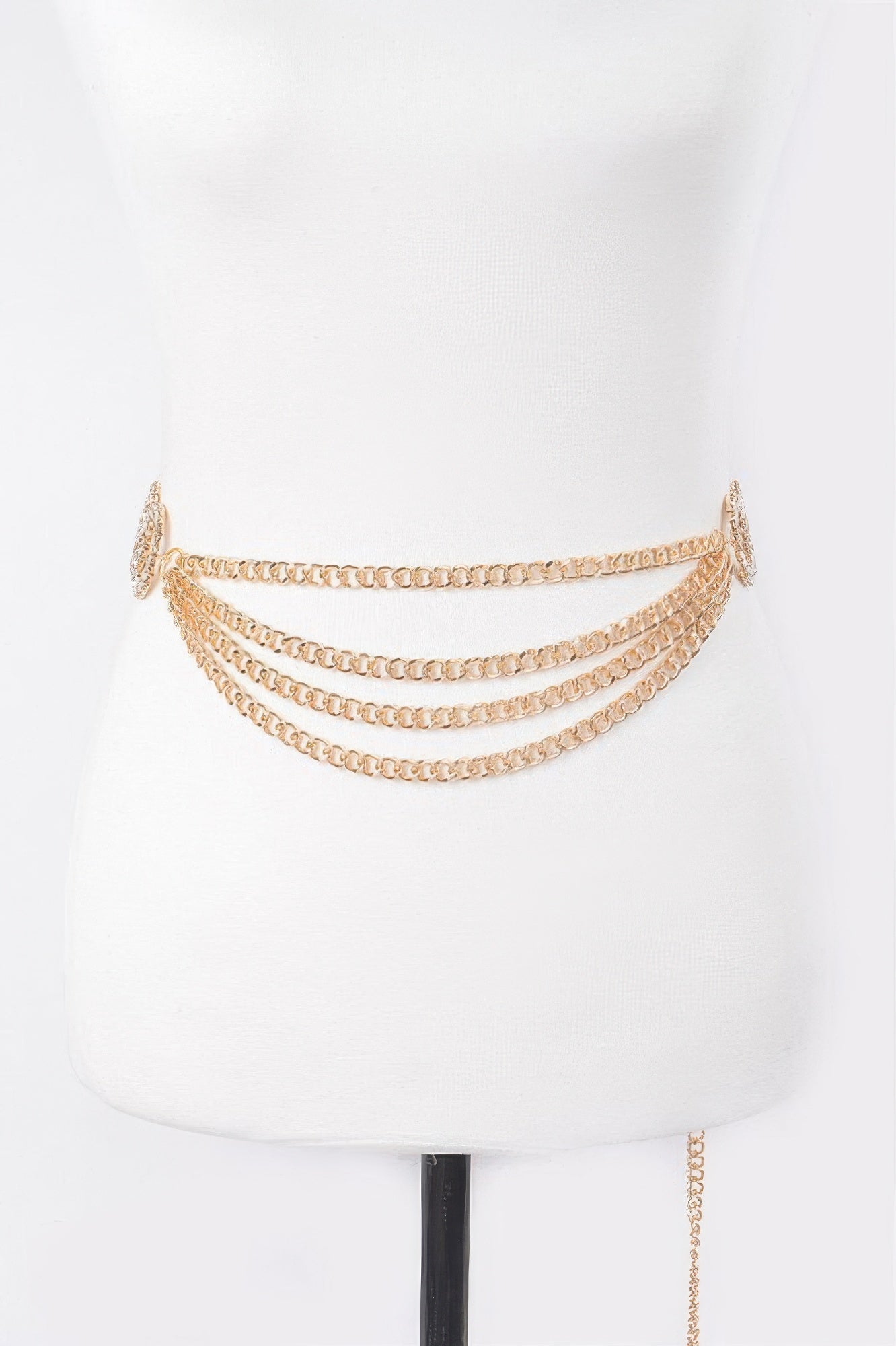 Gold layered chain belt draped across mannequin waist with round clasp charm