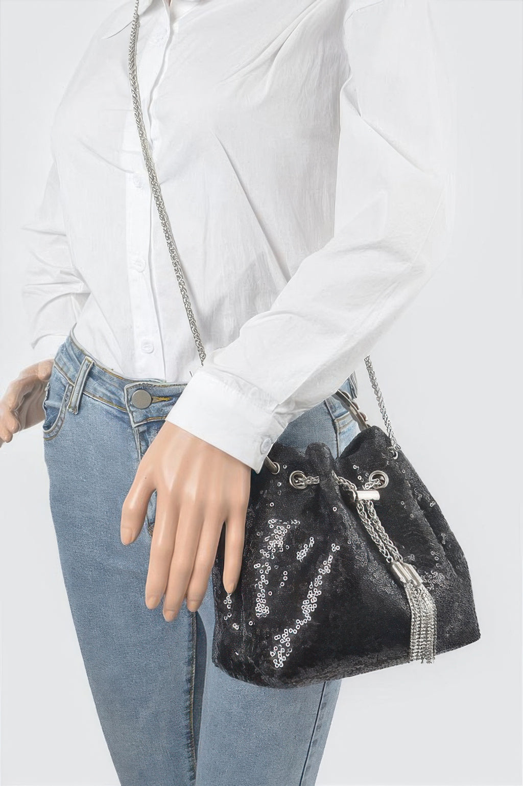 Sequin-Bucket-Bag schwarz getragen am Schultergurt, Kettenhenkel über dem Arm