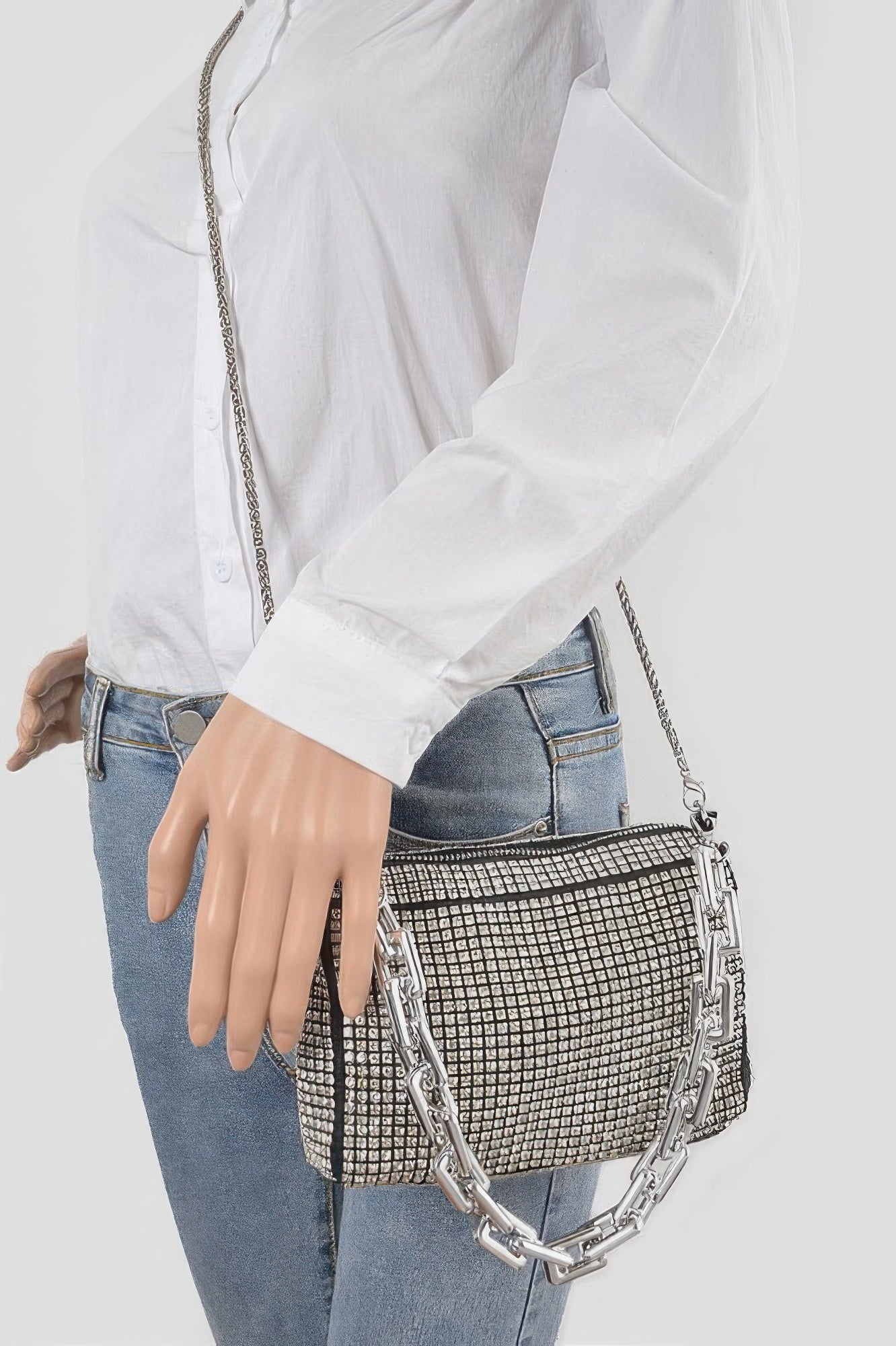 Silver rhinestone crossbody bag worn with chain shoulder strap and grid face