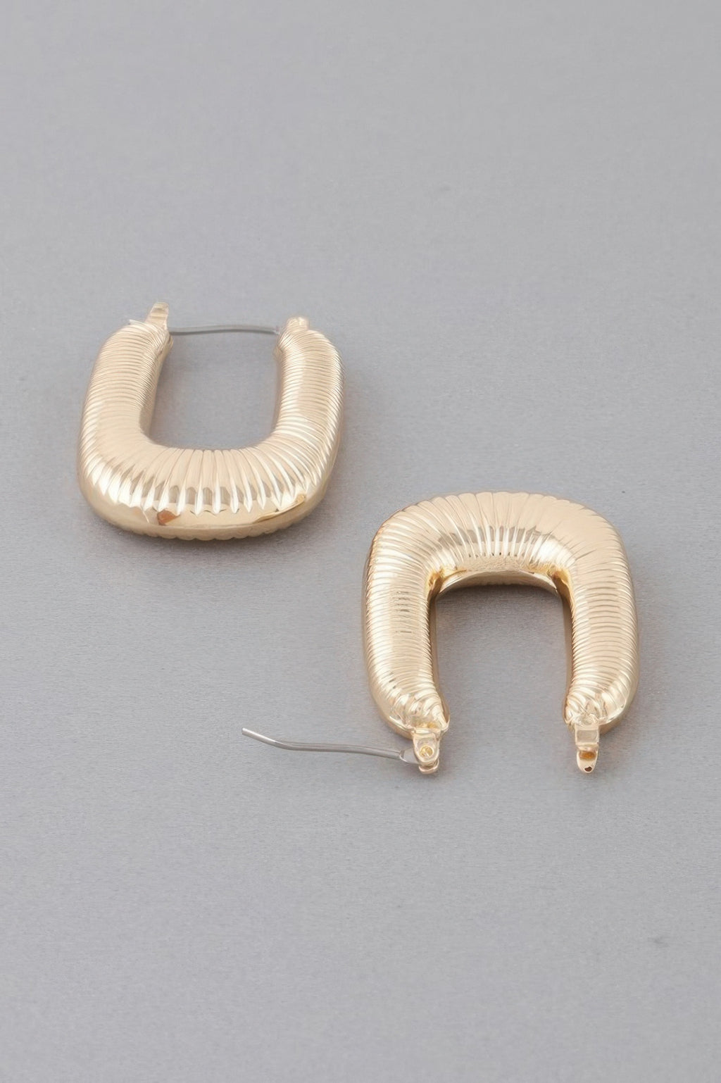 Gold-tone medium textured hoop earrings with ribbed surface and clasp backs
