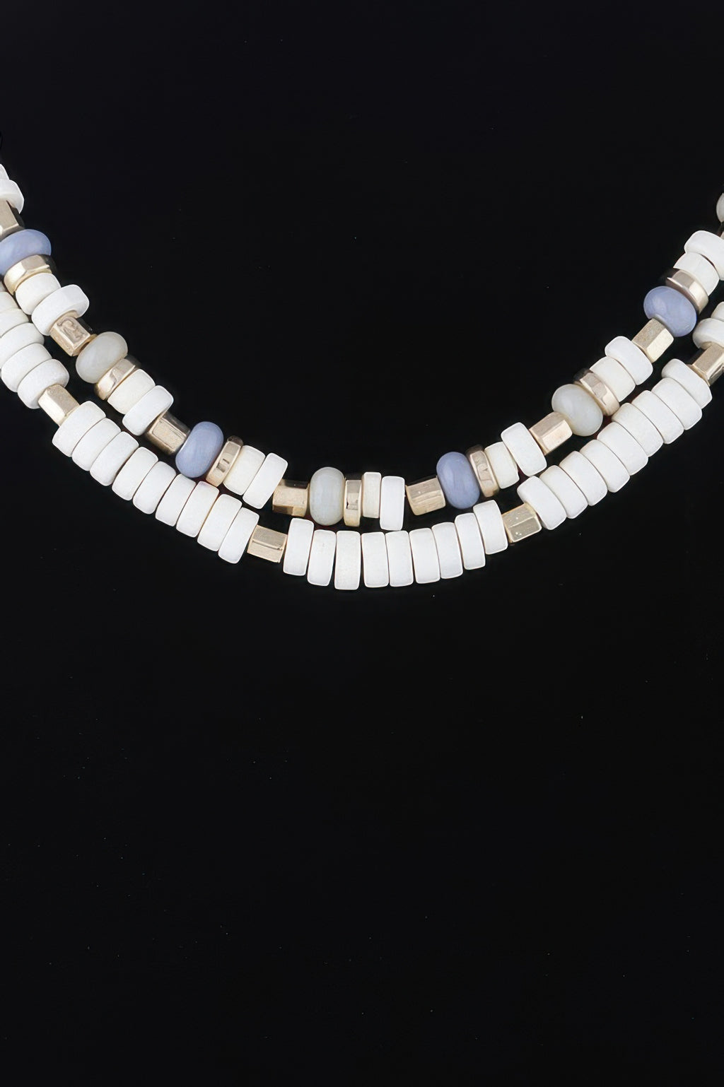 Close-up layered disk necklace: white beads with pale blue pieces and gold spacers